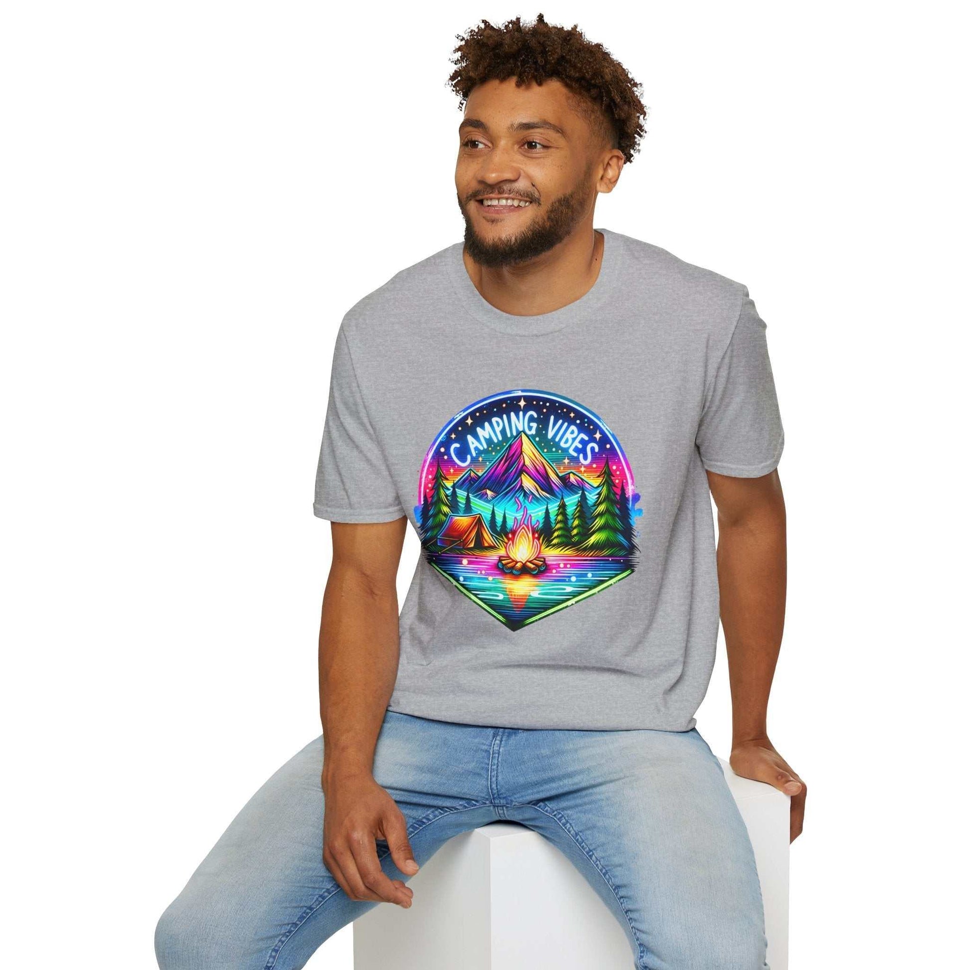 Man wearing gray Camping Vibes Unisex softstyle t-shirt with colorful camping graphic sitting on white block