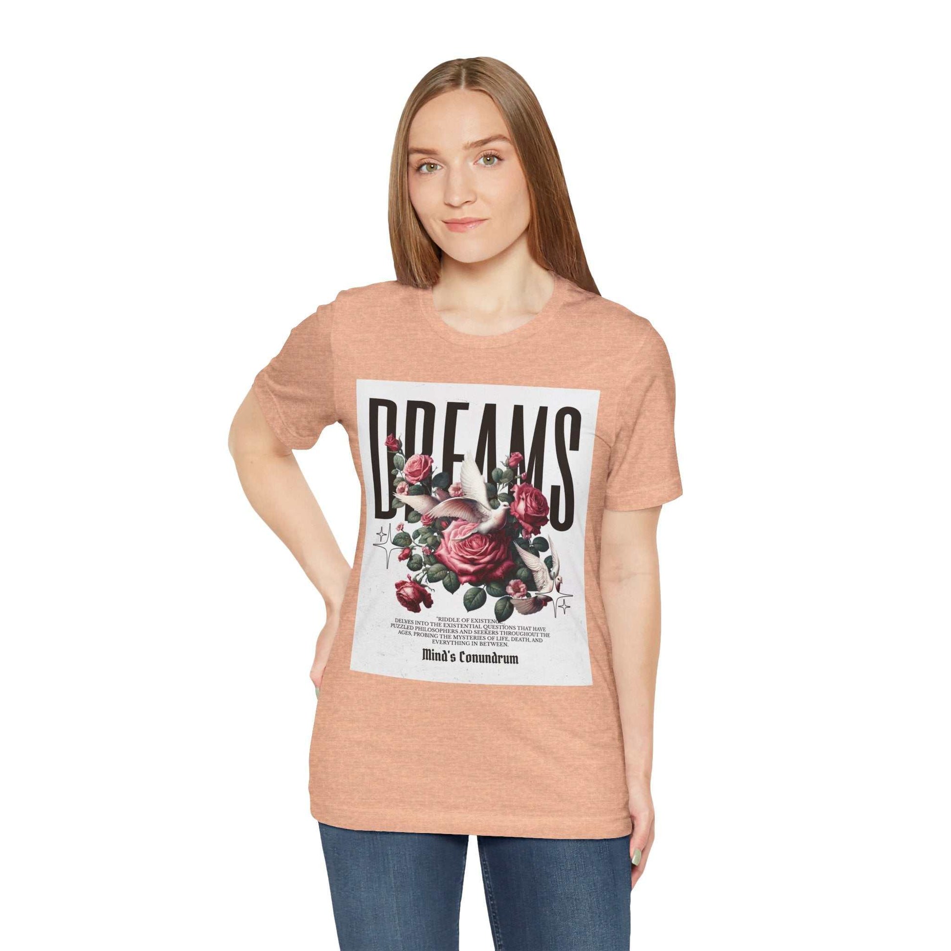 Woman wearing peach Dreams Floral Tee with large floral graphic and bold "DREAMS" text on front