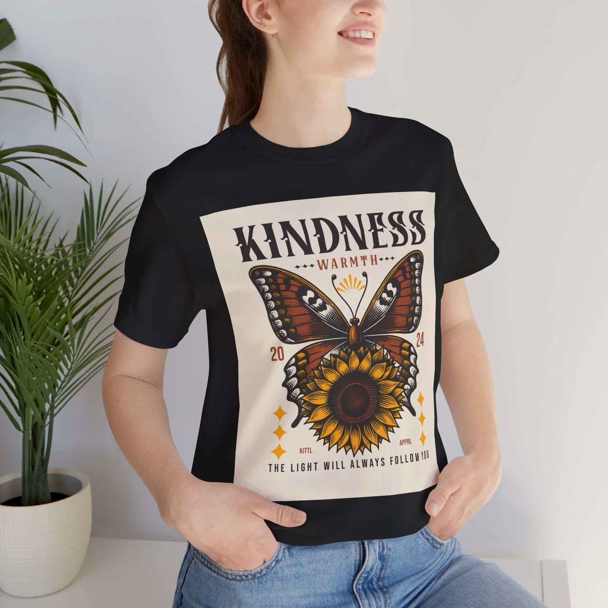 Woman wearing black Kindness Butterfly Tee with butterfly and sunflower graphic and positive message