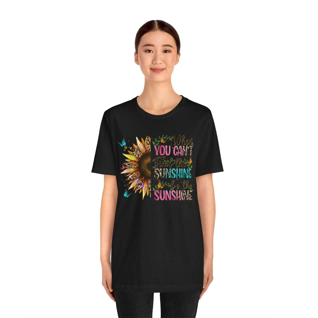 Woman wearing black Sunshine Quote Tee with colorful sunflower and uplifting text design