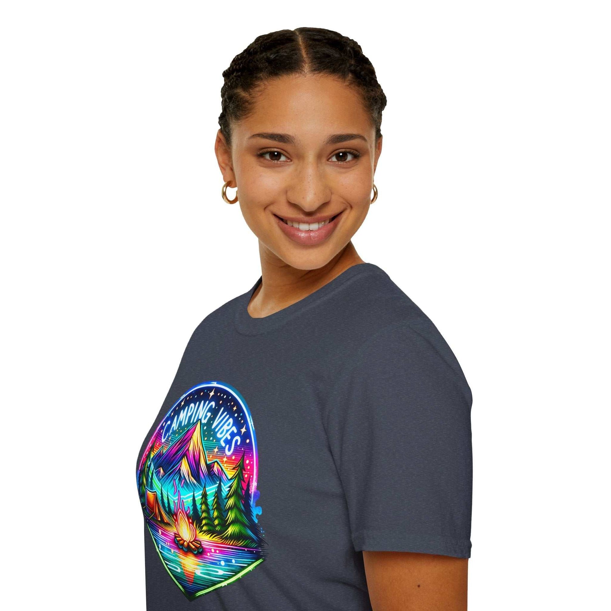 Woman wearing a Camping Vibes Unisex Softstyle T-Shirt with colorful mountain and campfire graphic on dark fabric