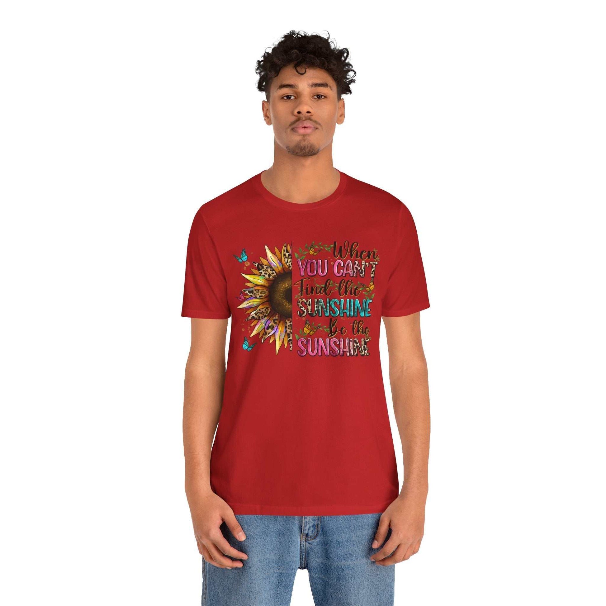 Man wearing red Sunshine Quote Tee with sunflower and positive quote design on front