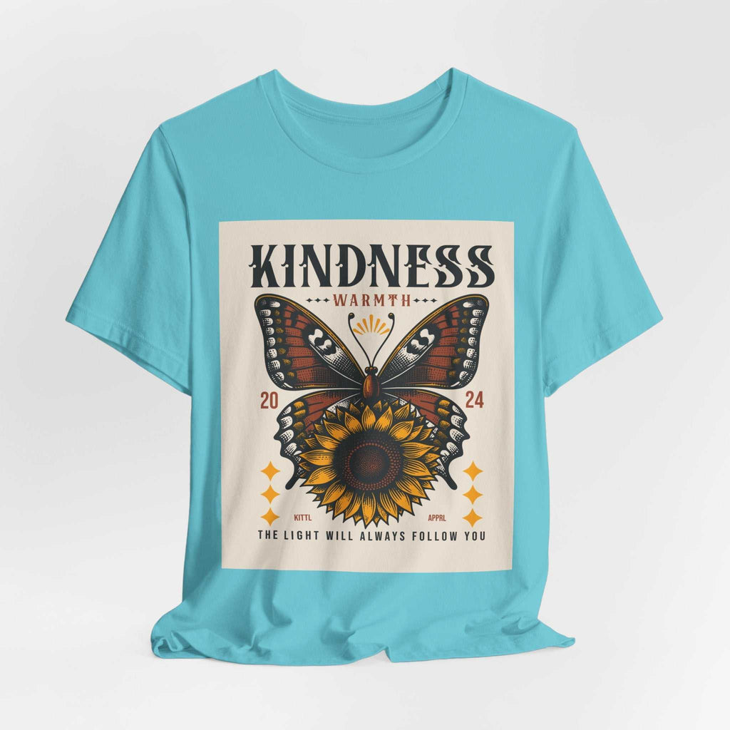 Light blue Kindness Butterfly Tee featuring a butterfly and sunflower design with the words "Kindness Warmth 2024" and the phrase "The light will always follow you" on the front.