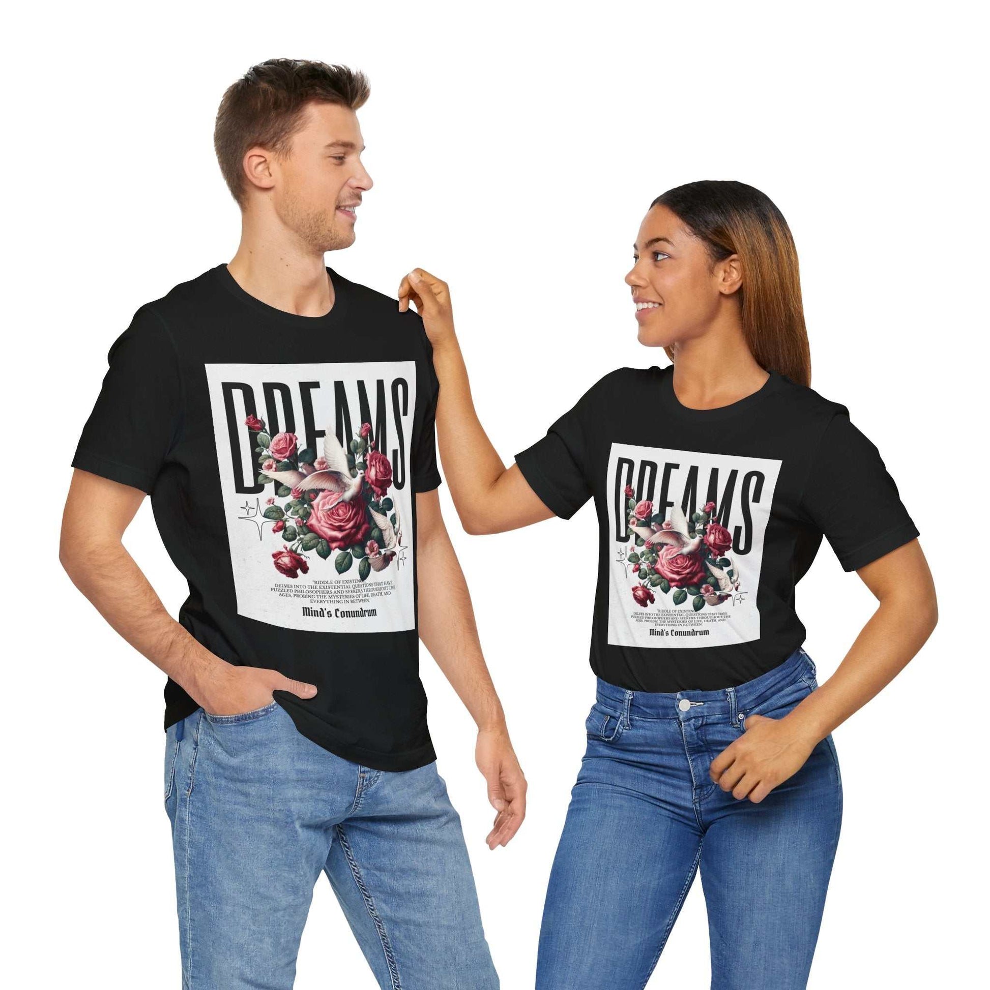 Unisex black Dreams Floral Tee featuring a bold floral design with roses and typography, modeled by a man and woman wearing casual blue jeans.