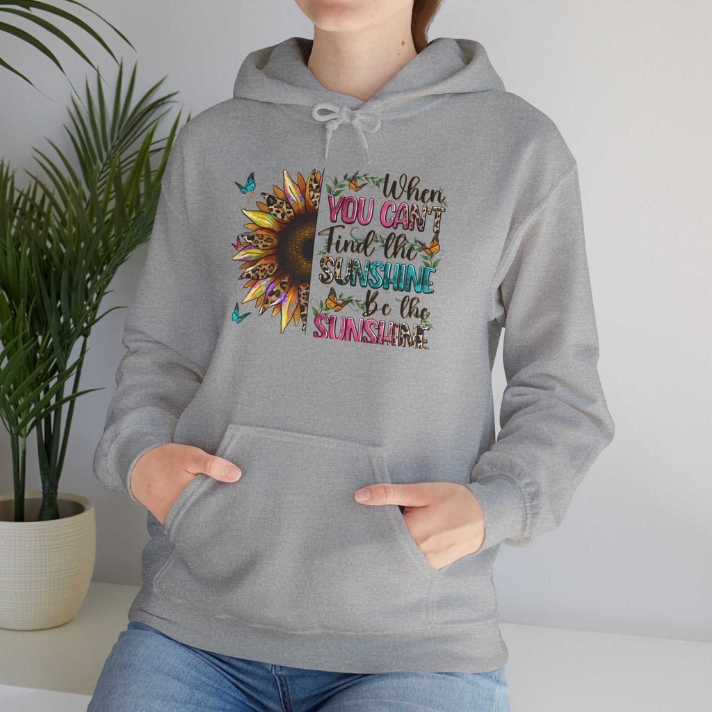 Gray sunflower quote hoodie with inspirational colorful text and butterfly design, worn by person with hands in front pocket