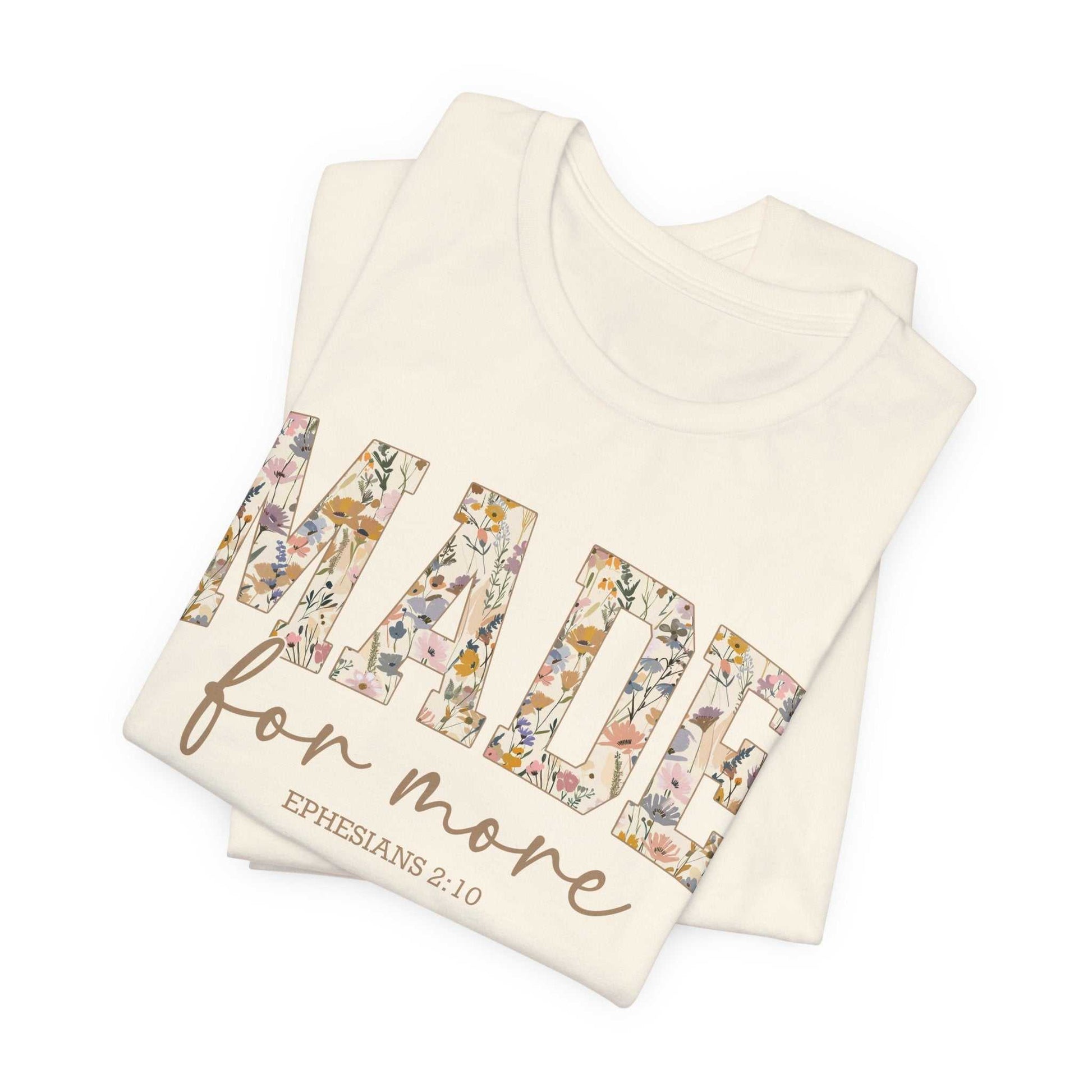 White Made for More Tee with floral patterned text and Ephesians 2:10 scripture design, folded view