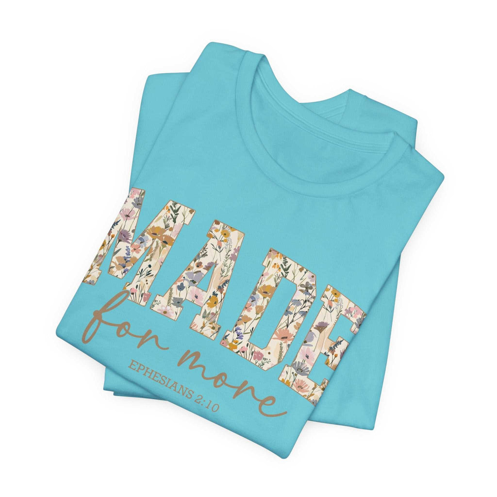 Folded light blue Made for More Tee with floral patterned text and scripture reference on front