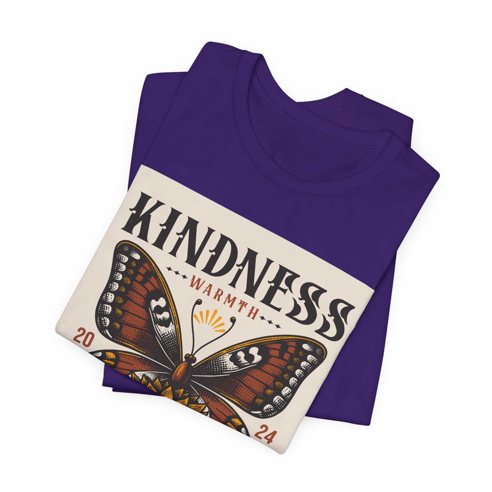Folded purple Kindness Butterfly Tee with butterfly and sunflower graphic and "Kindness Warmth" text design