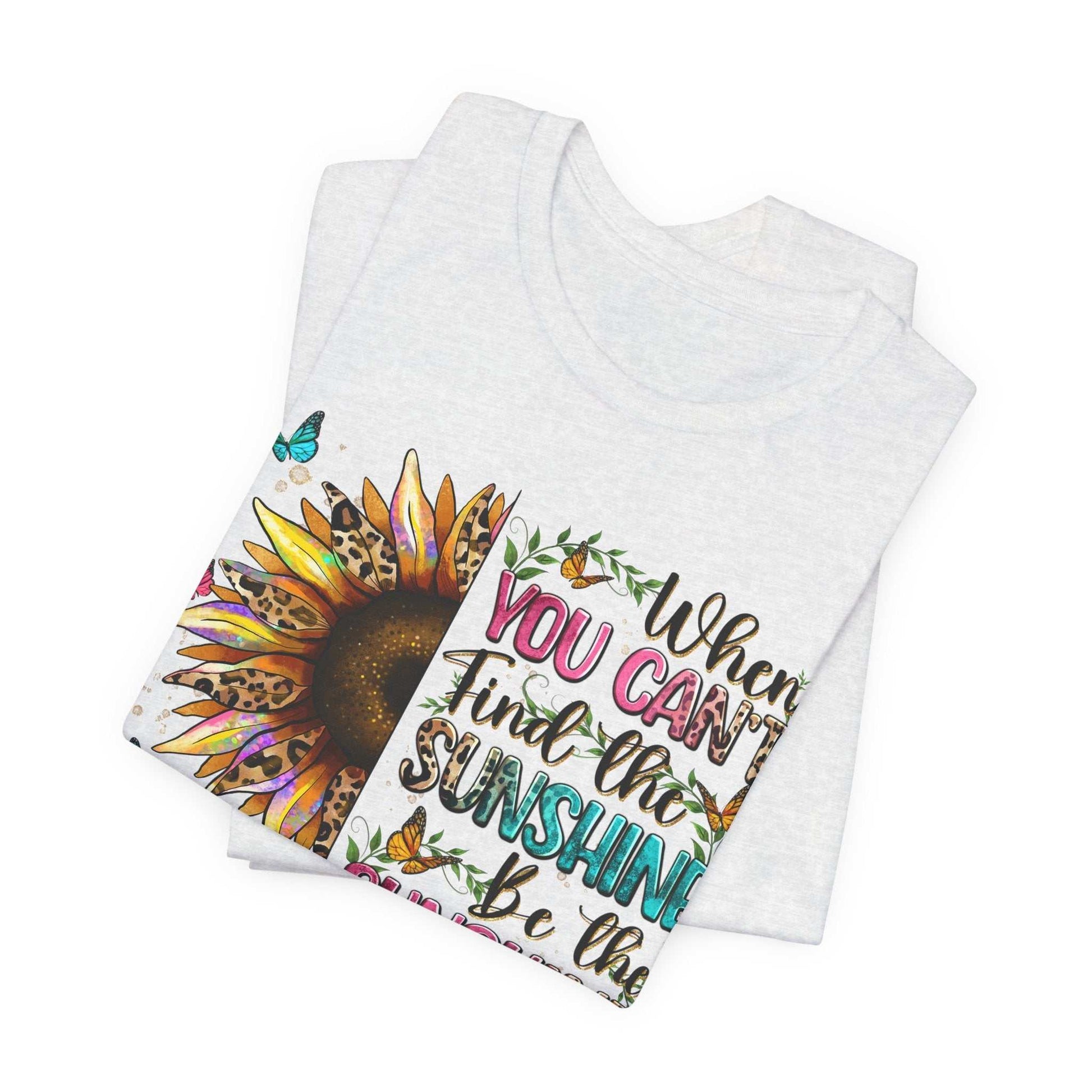 Folded white Sunshine Quote Tee with vibrant sunflower and inspirational text design on front
