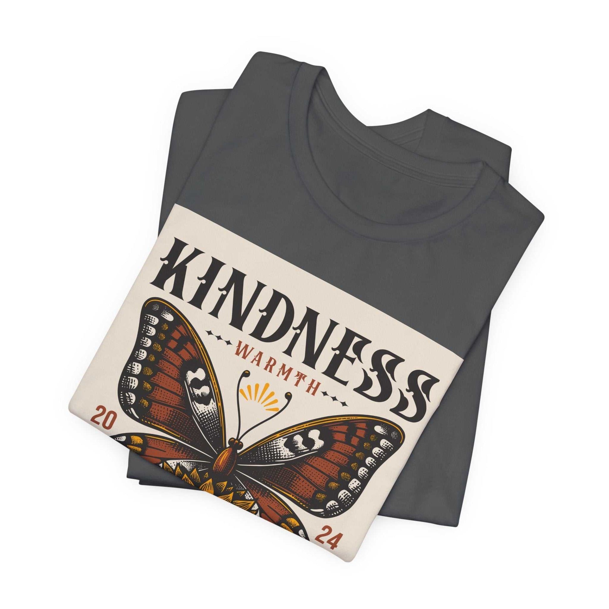 Folded charcoal gray Kindness Butterfly Tee with butterfly graphic and text warmth 2024 on front