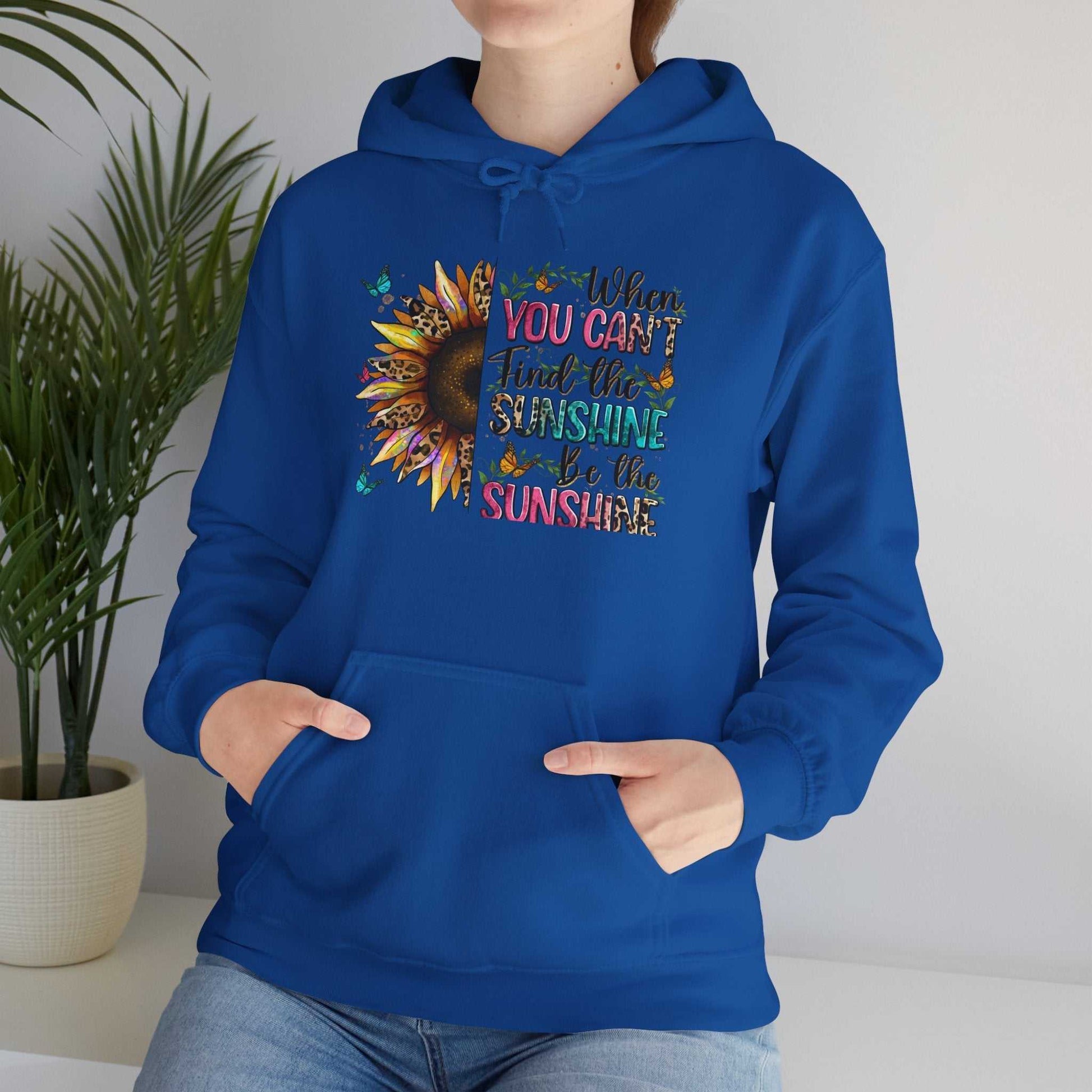 Blue sunflower quote hoodie with inspirational "When you can't find the sunshine be the sunshine" text and kangaroo pocket