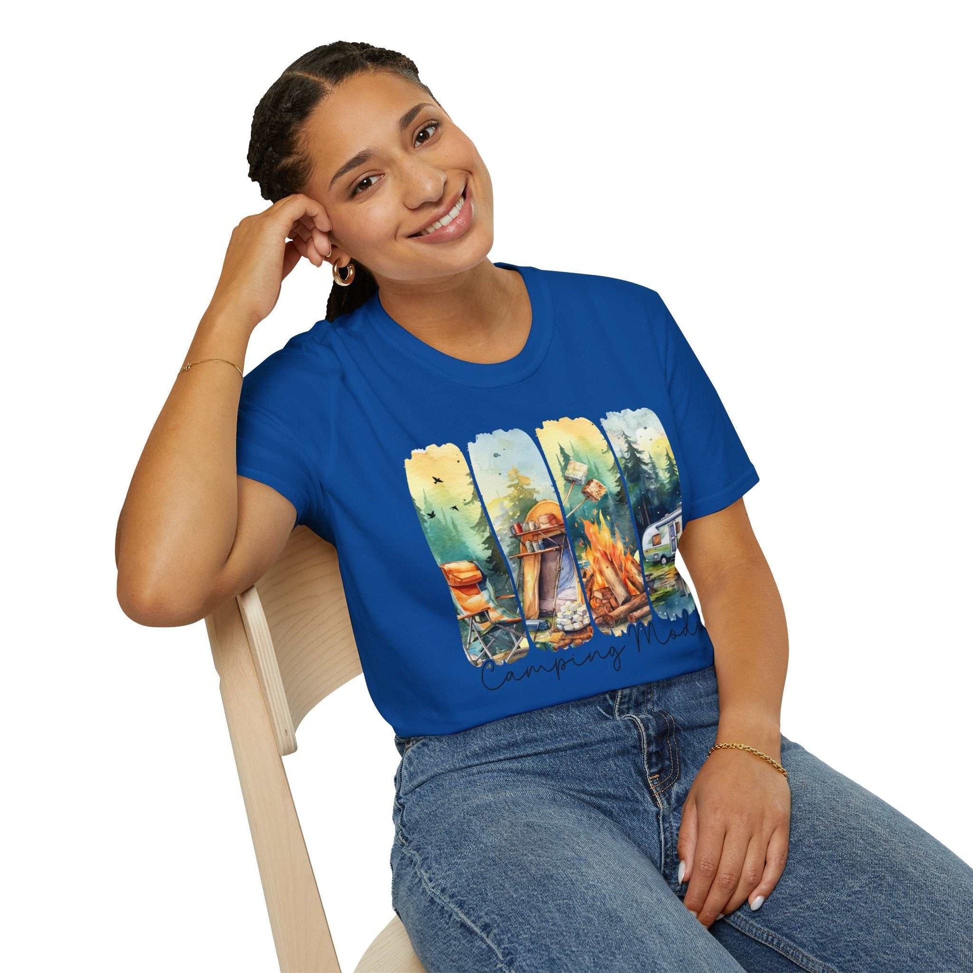 Woman wearing blue Camping Adventure Unisex T-Shirt with outdoor camping graphic sitting on chair smiling