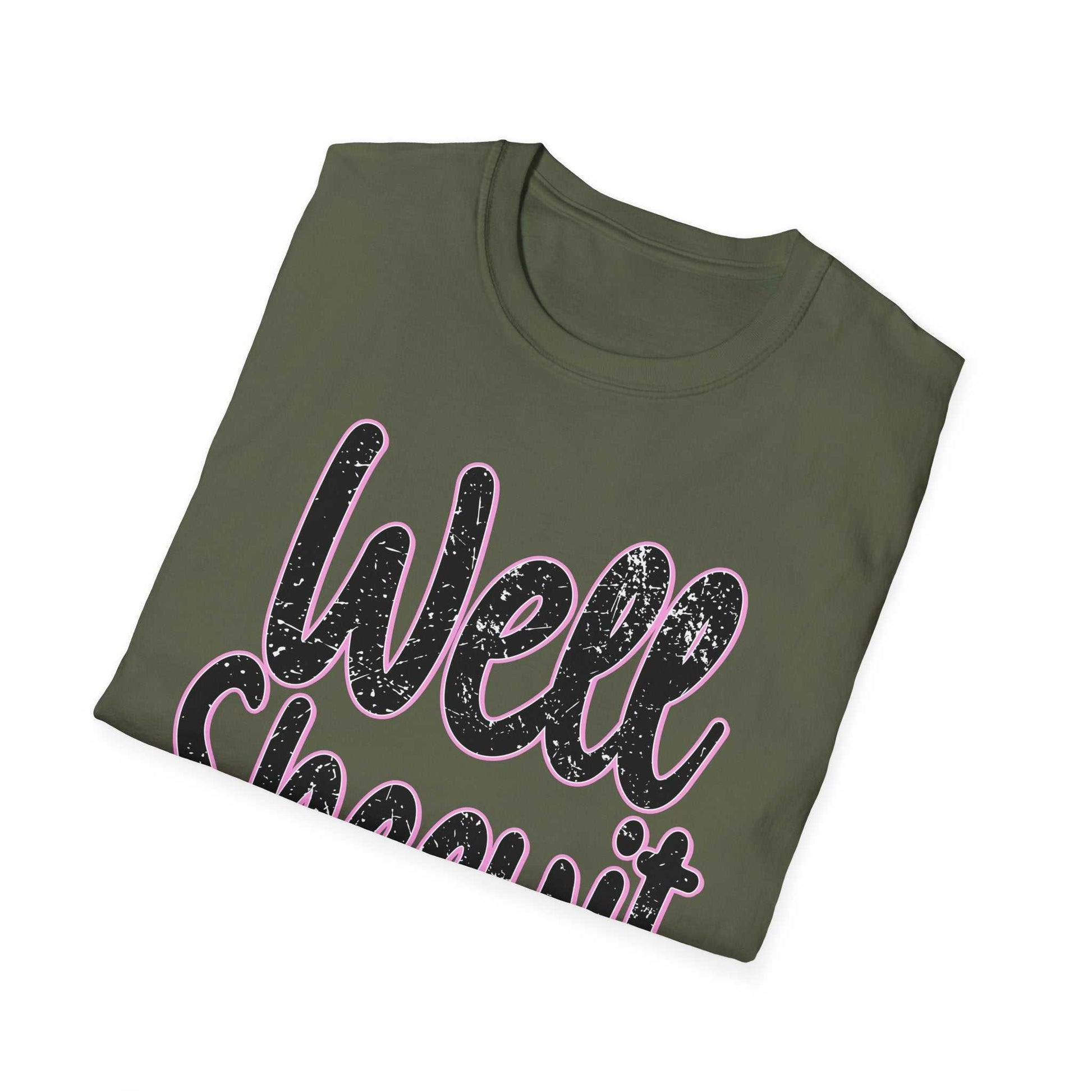 Folded olive green casual statement tee with "Well Sheeyit" printed in distressed black and pink text