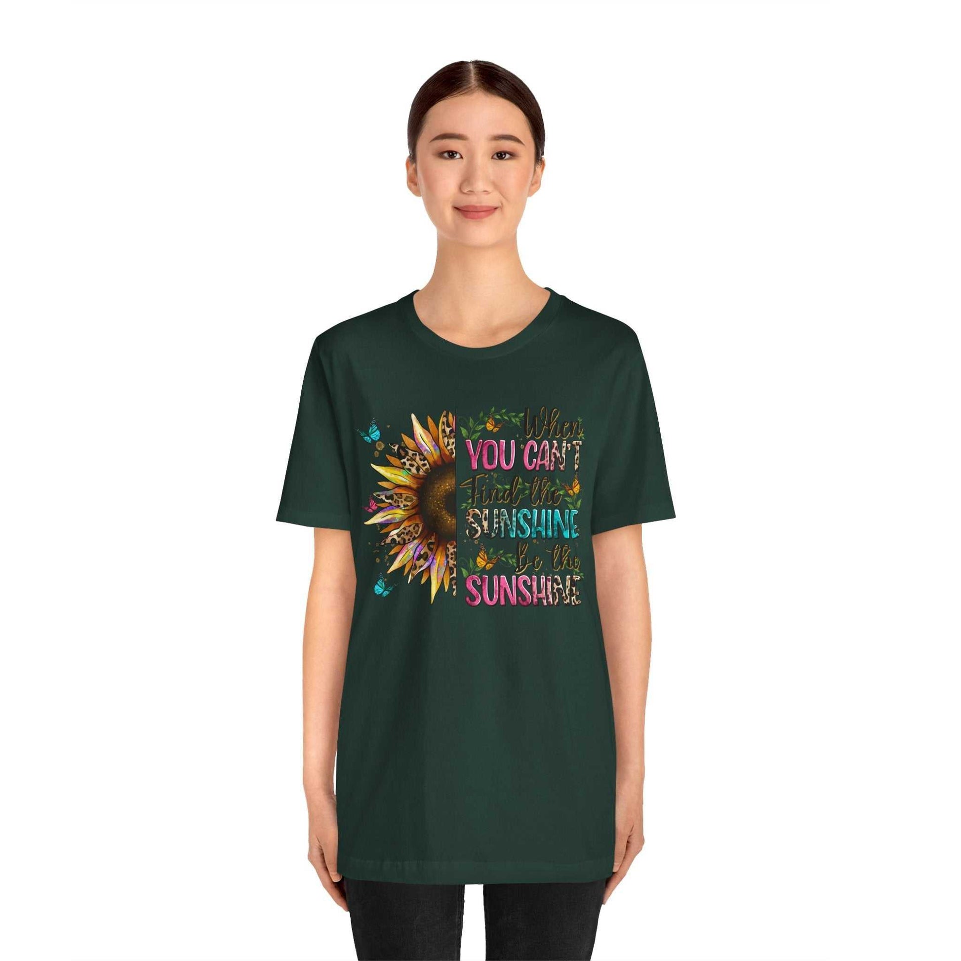 woman wearing dark green Sunshine Quote Tee with colorful sunflower and motivational text design