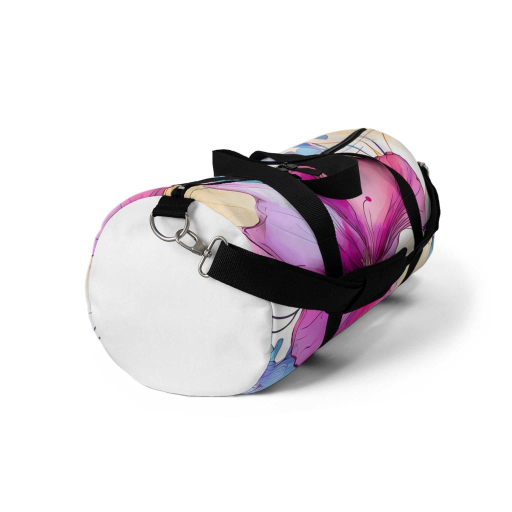 Small floral duffel bag with vibrant pink and purple flower design, black adjustable strap, and cylindrical shape for gym or travel use