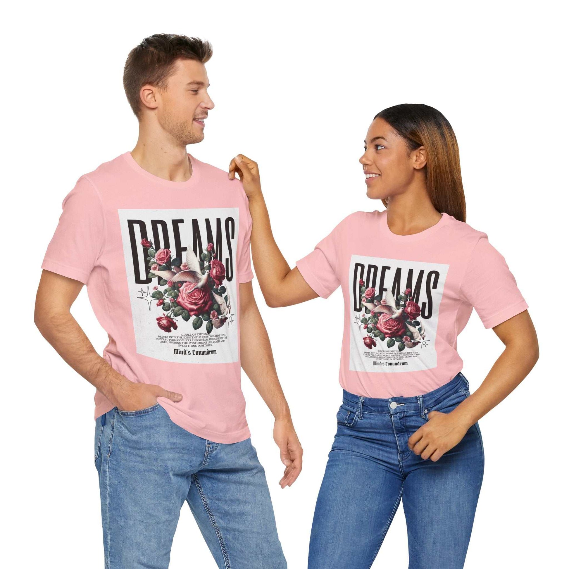 Two models wearing pink Dreams Floral Tee with large floral and bold typography print on front, paired with blue jeans.