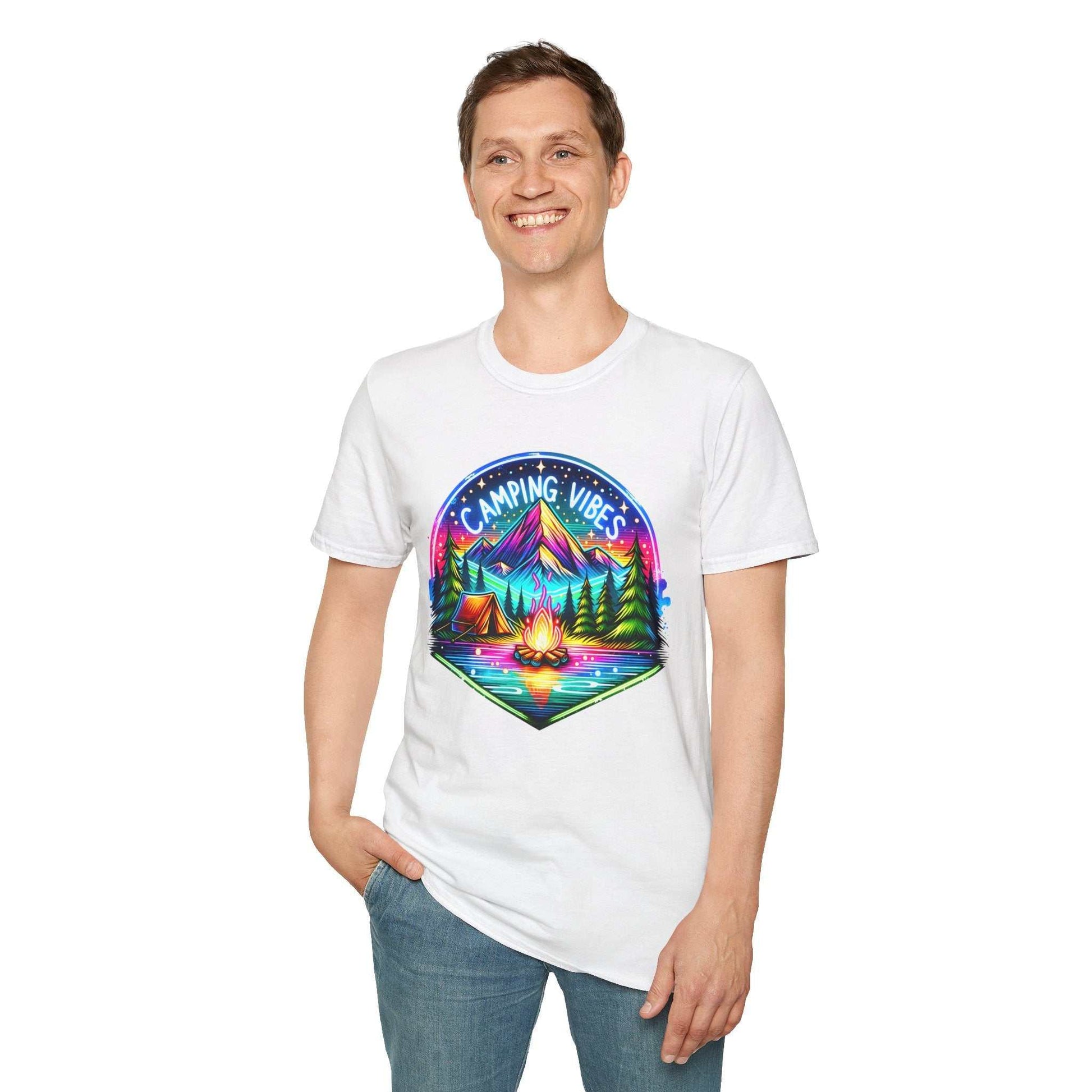 Unisex white softstyle t-shirt with colorful camping vibes design featuring a campfire, tent, and mountains, worn by smiling man
