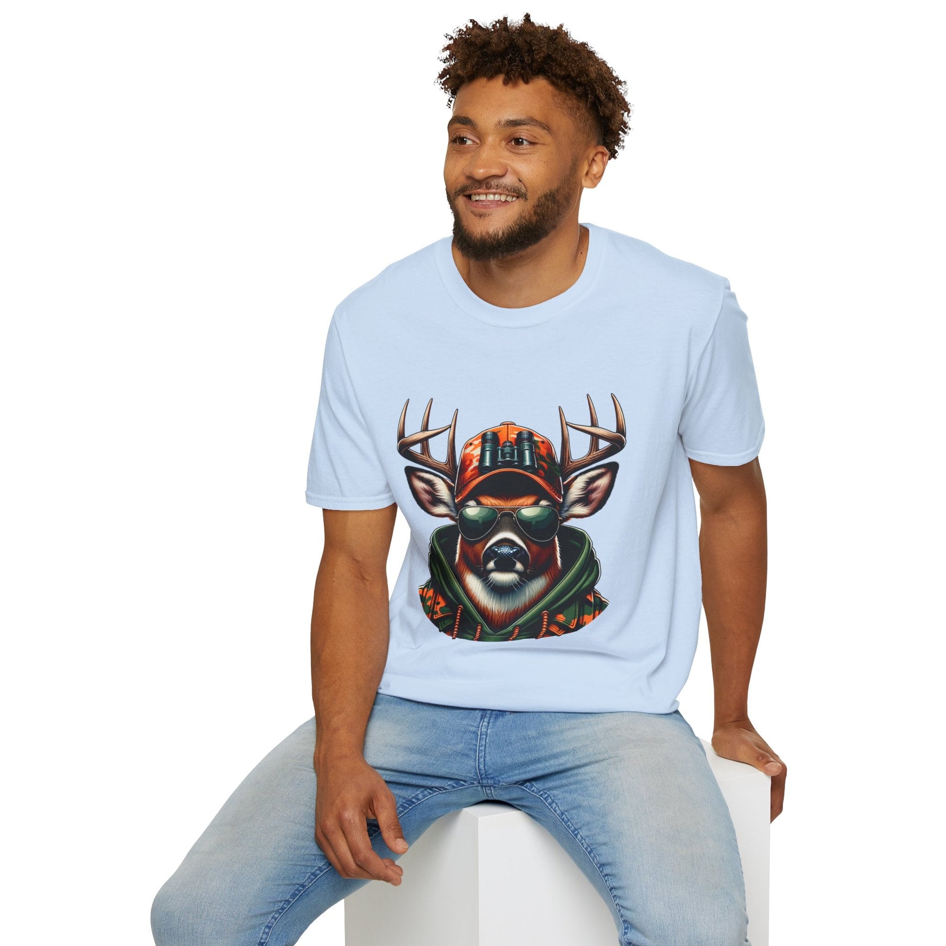 Man wearing light blue Hunting Enthusiast T-Shirt with deer graphic and sunglasses sitting on white cube