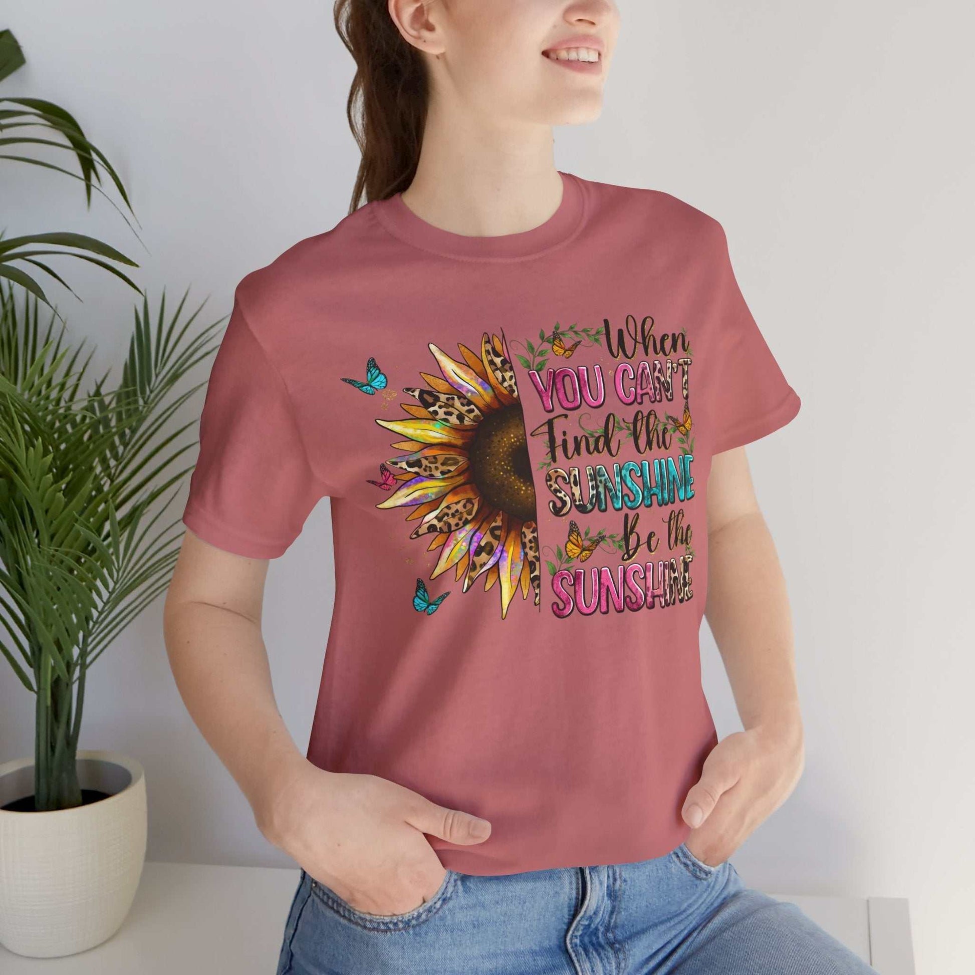 Woman wearing a pink Sunshine Quote Tee with sunflower and butterflies graphic and positive text design