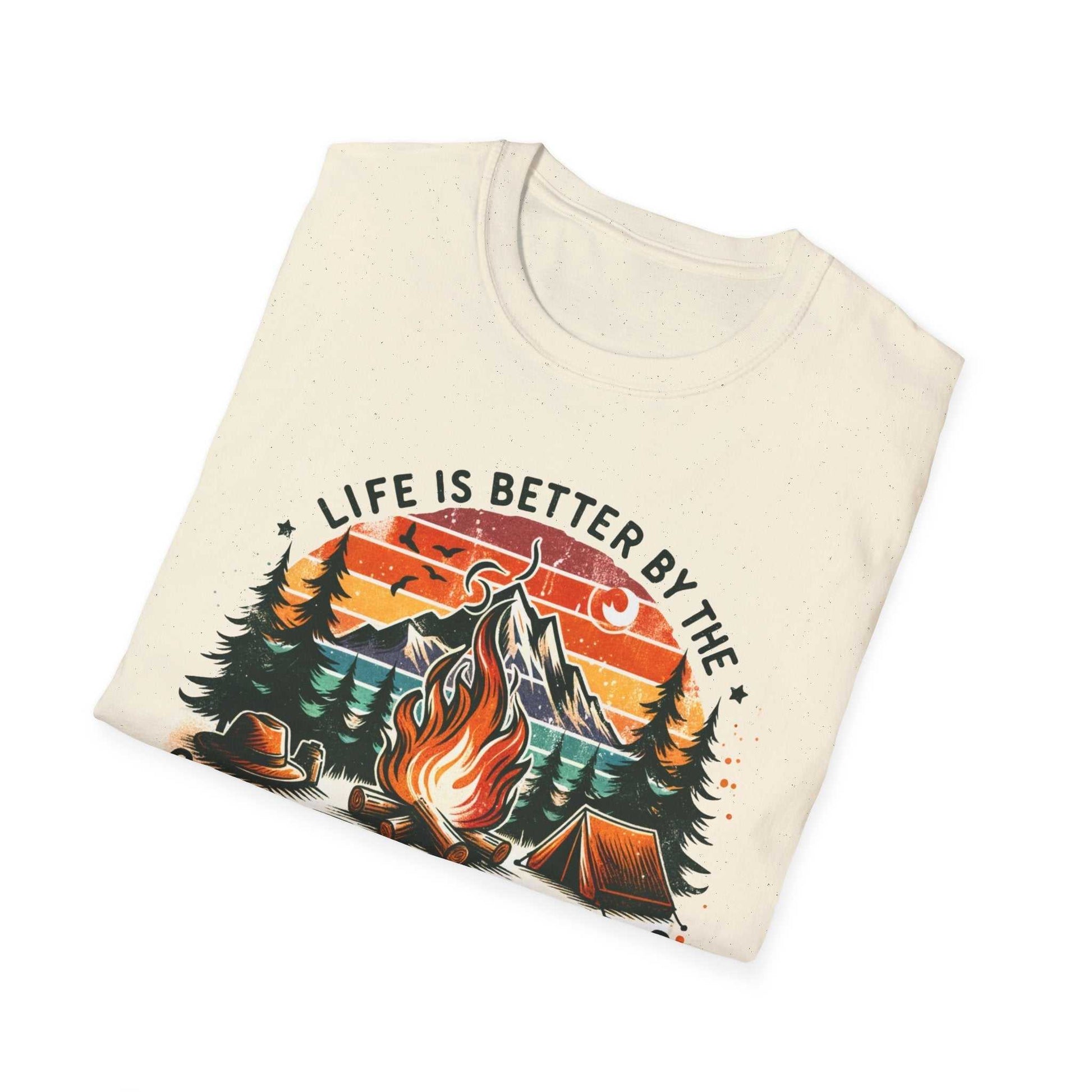 Camping Adventure Unisex T-Shirt with campfire, mountain, trees, and sunset design and "Life is Better by the Campfire" text on cream background