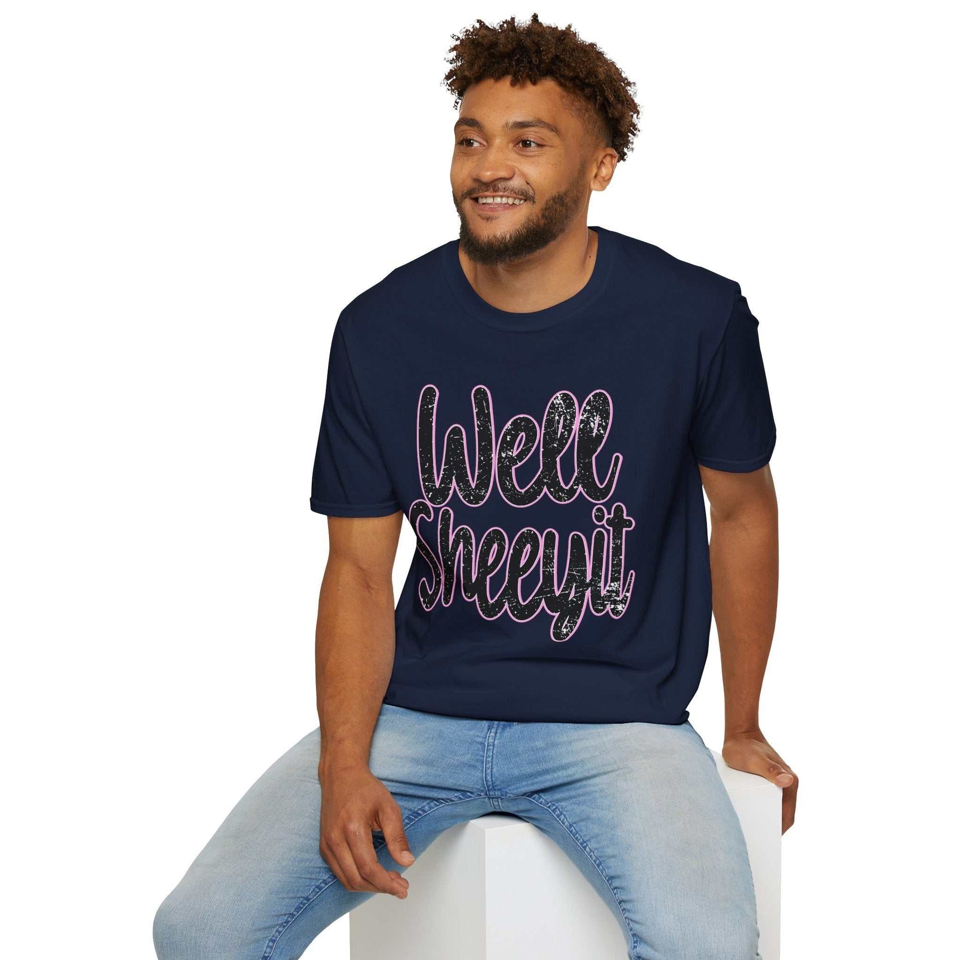 Man wearing navy casual statement tee with funny "Well Sheeyit" quote sitting on white block