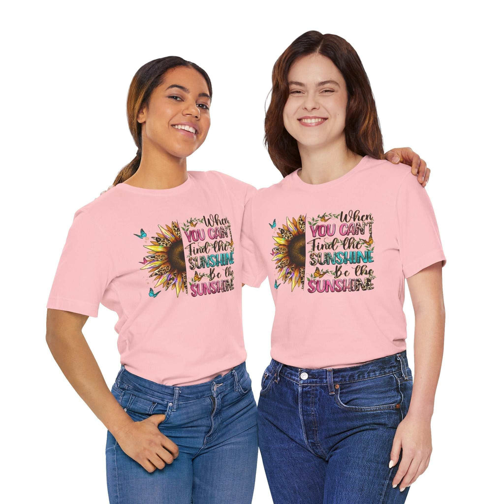 Two women wearing pink Sunshine Quote Tee shirts with sunflower and inspirational text design, styled casually with jeans