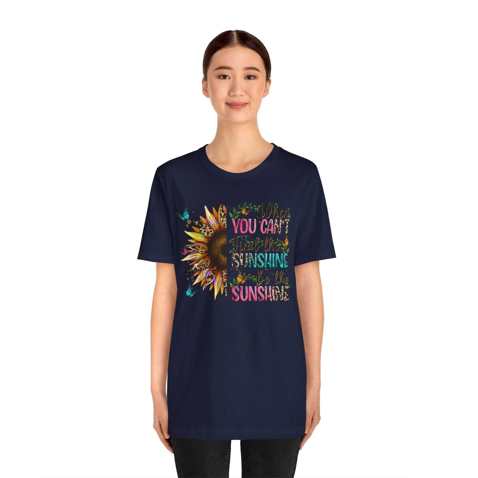 Woman wearing navy Sunshine Quote Tee with colorful sunflower and inspirational text design