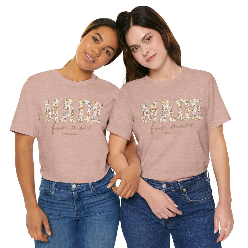Two women wearing pink "Made for More" floral print unisex t-shirts paired with blue jeans