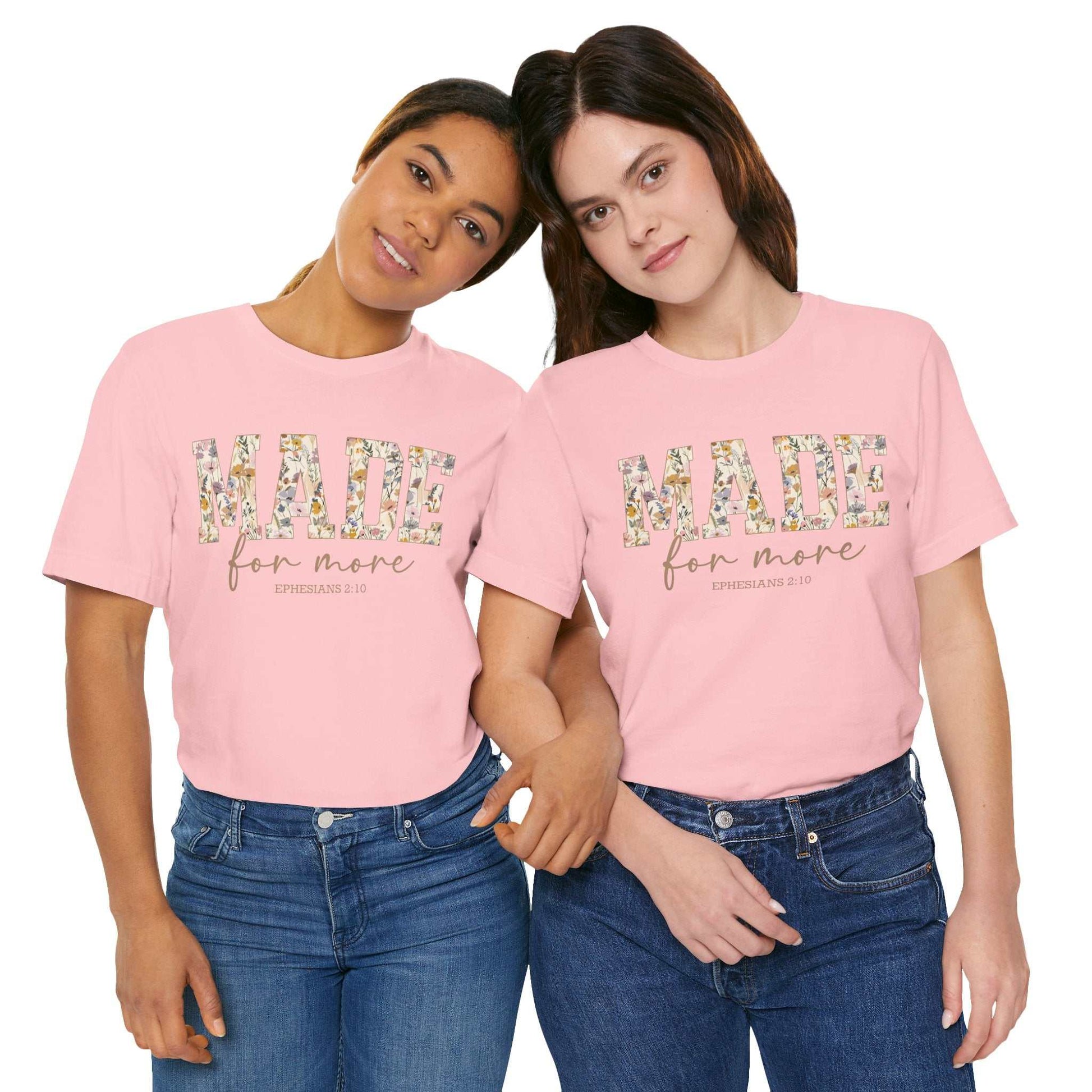 Two women wearing pink "Made for More" floral print short sleeve tees paired with blue jeans