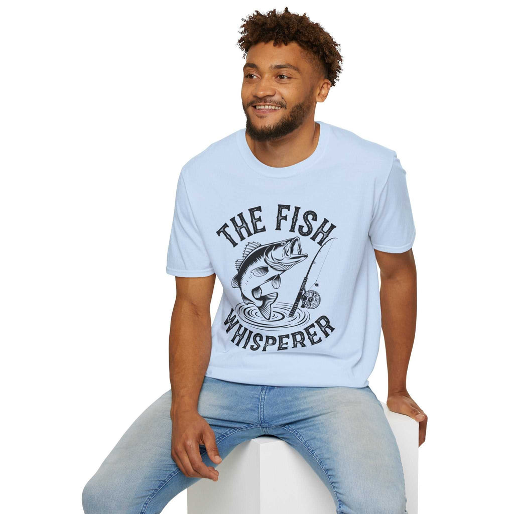 Man wearing light blue unisex t-shirt with "The Fish Whisperer" fishing graphic design.
