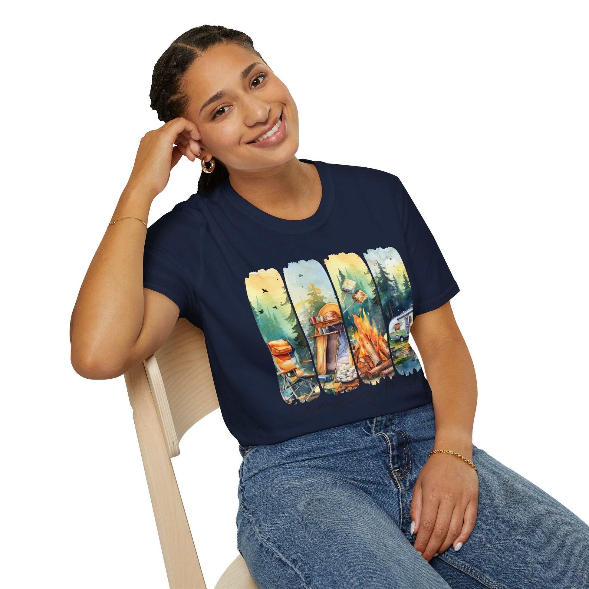 Woman wearing navy blue Camping Adventure unisex t-shirt with colorful camping-themed graphic sitting on wooden chair