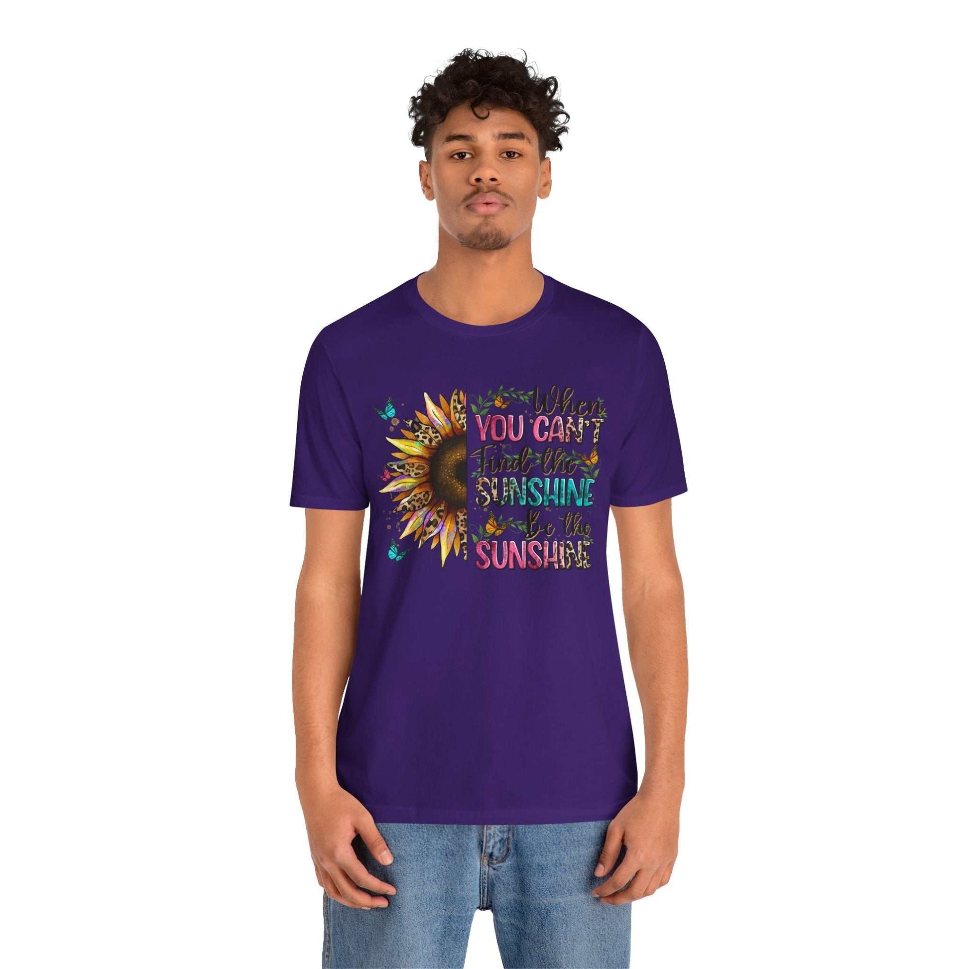 Man wearing purple Sunshine Quote Tee with colorful sunflower and uplifting text design on front