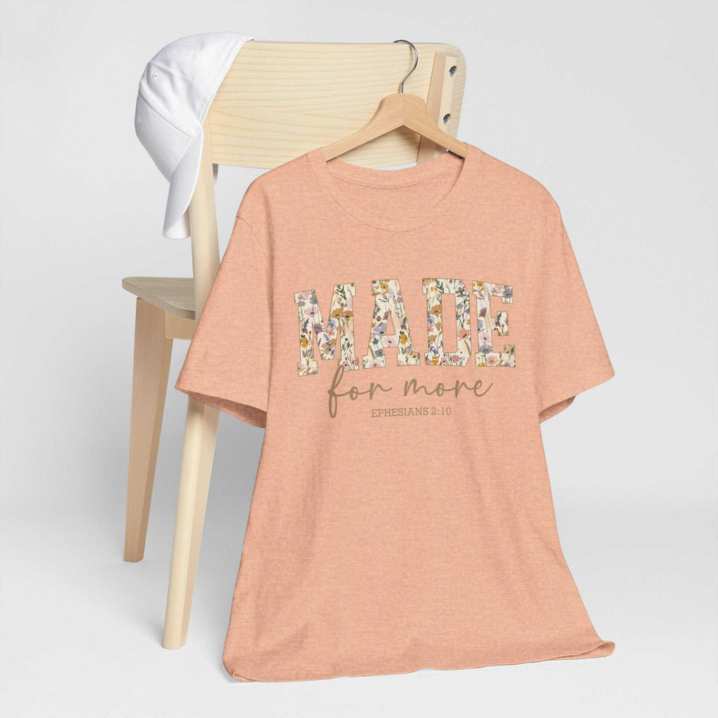 Made for More Tee peach floral print unisex short sleeve shirt on wooden chair with white cap background