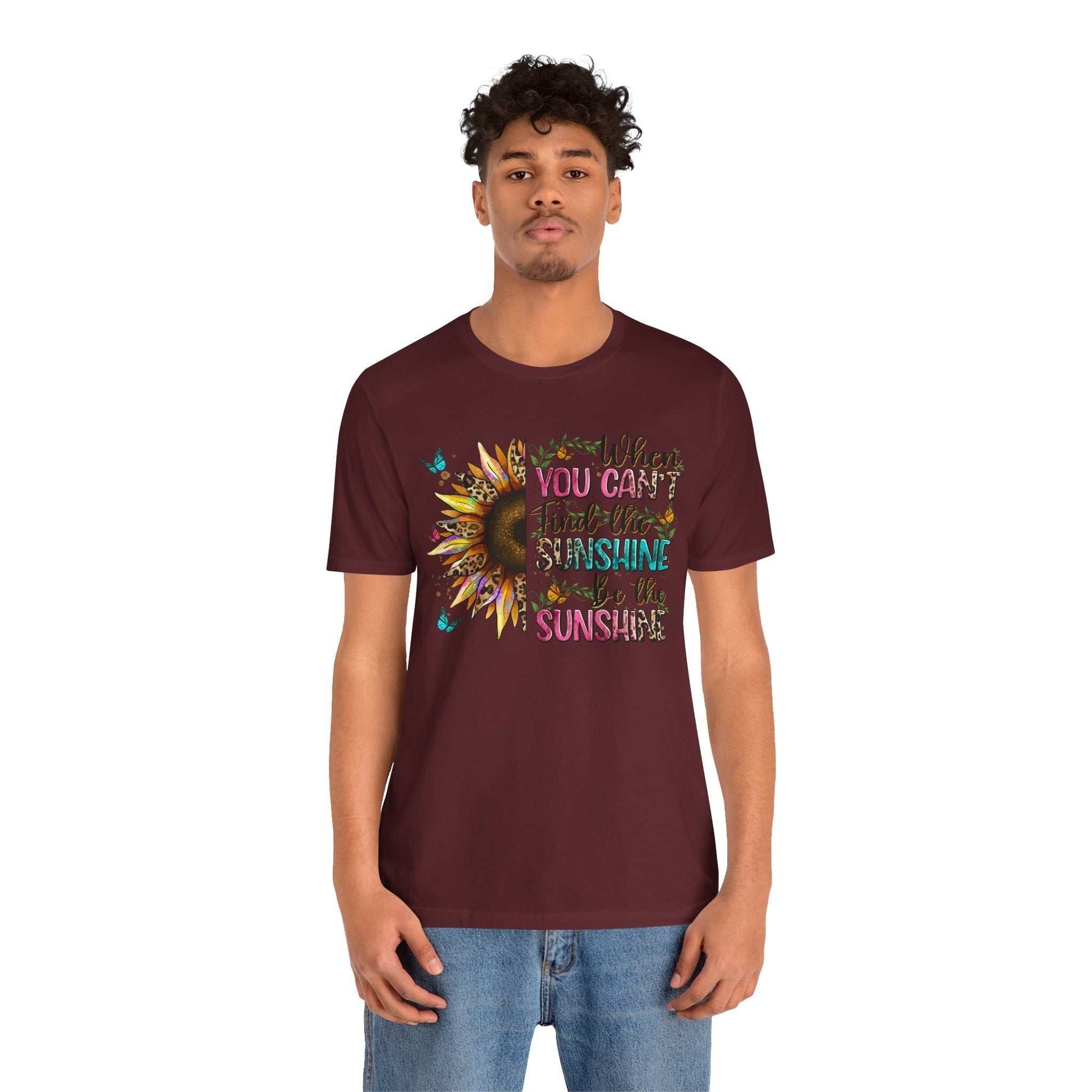 Man wearing maroon Sunshine Quote Tee with colorful sunflower and positive quote design