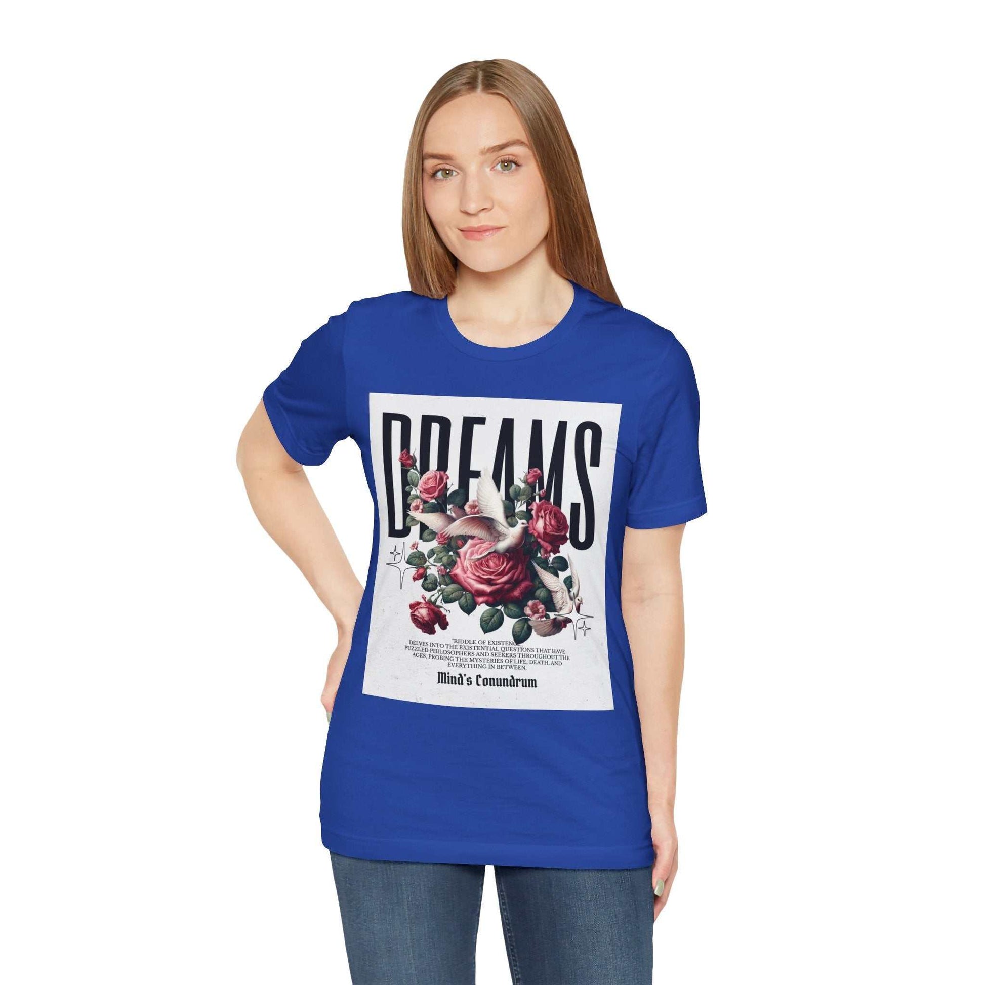 Woman wearing a blue Dreams Floral Tee with bold typography and floral design on front, paired with jeans.