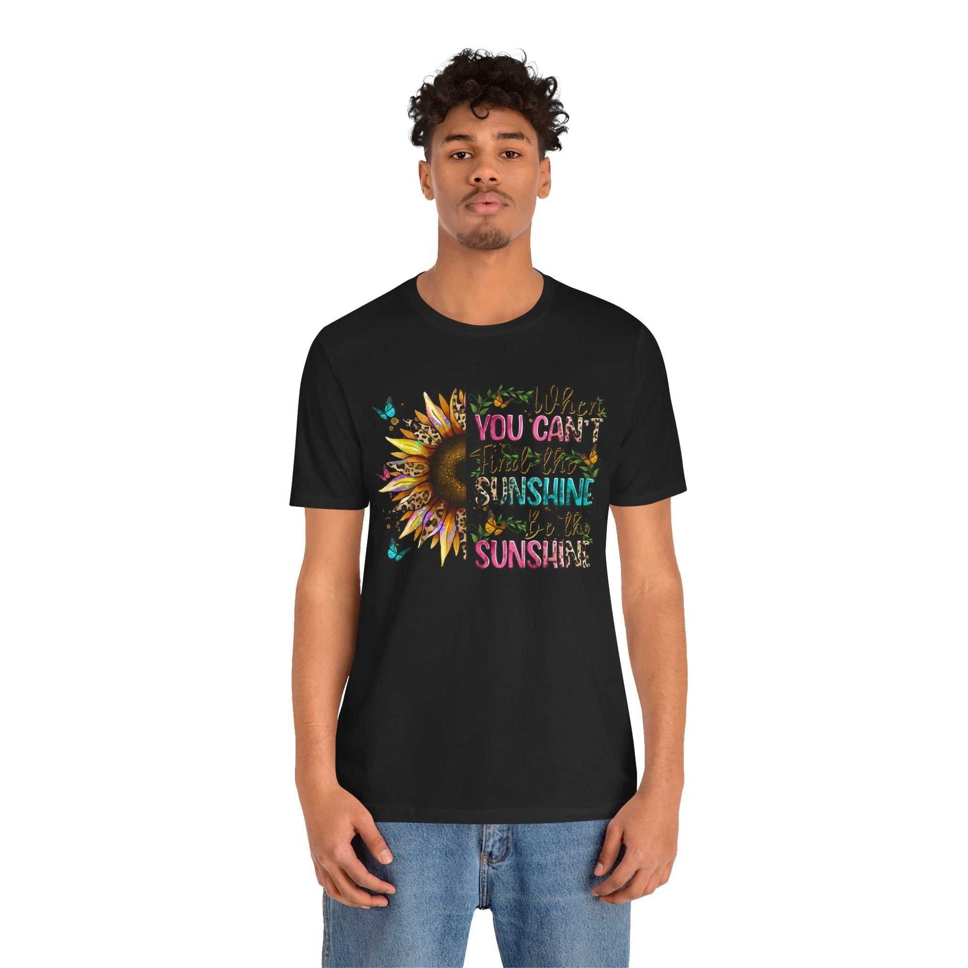 Man wearing black Sunshine Quote Tee with colorful sunflower and positive quote design on front