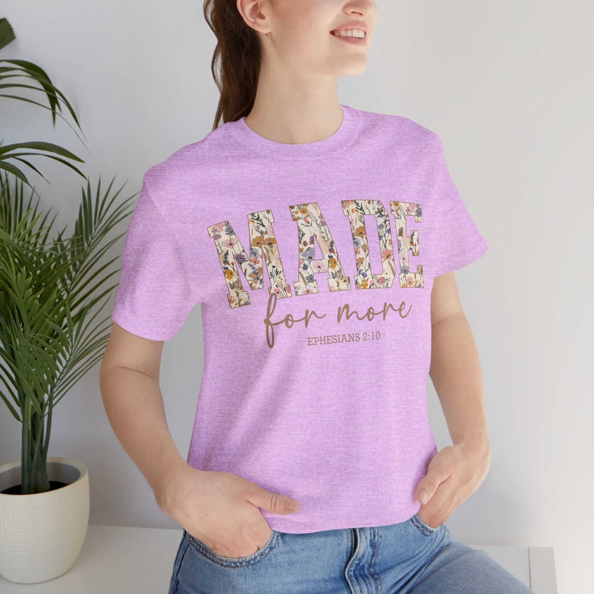 Woman wearing a lavender "Made for More" floral print unisex jersey short sleeve tee with relaxed fit and ribbed collar.