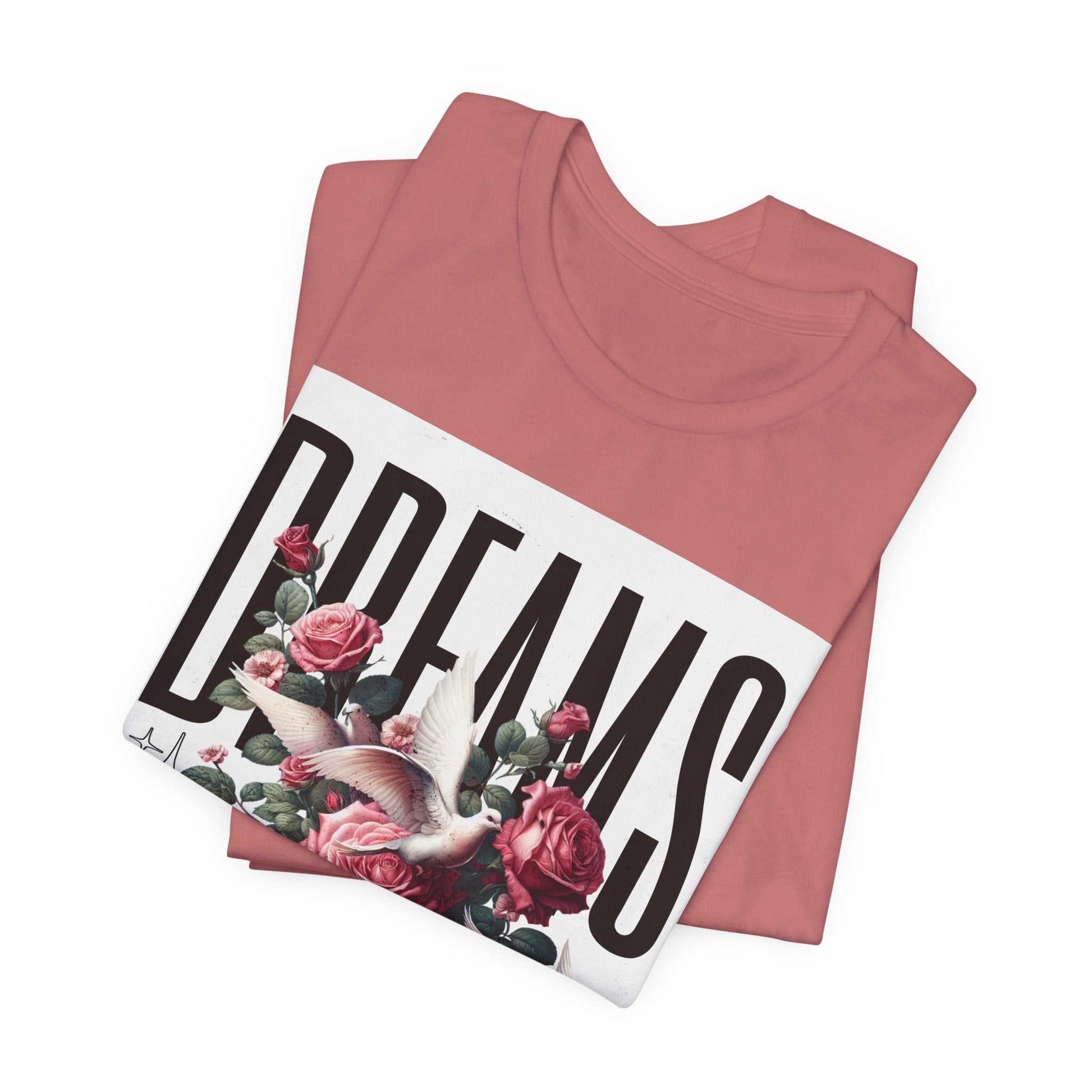 Folded dusty rose Dreams Floral Tee with large floral and dove graphic and bold text