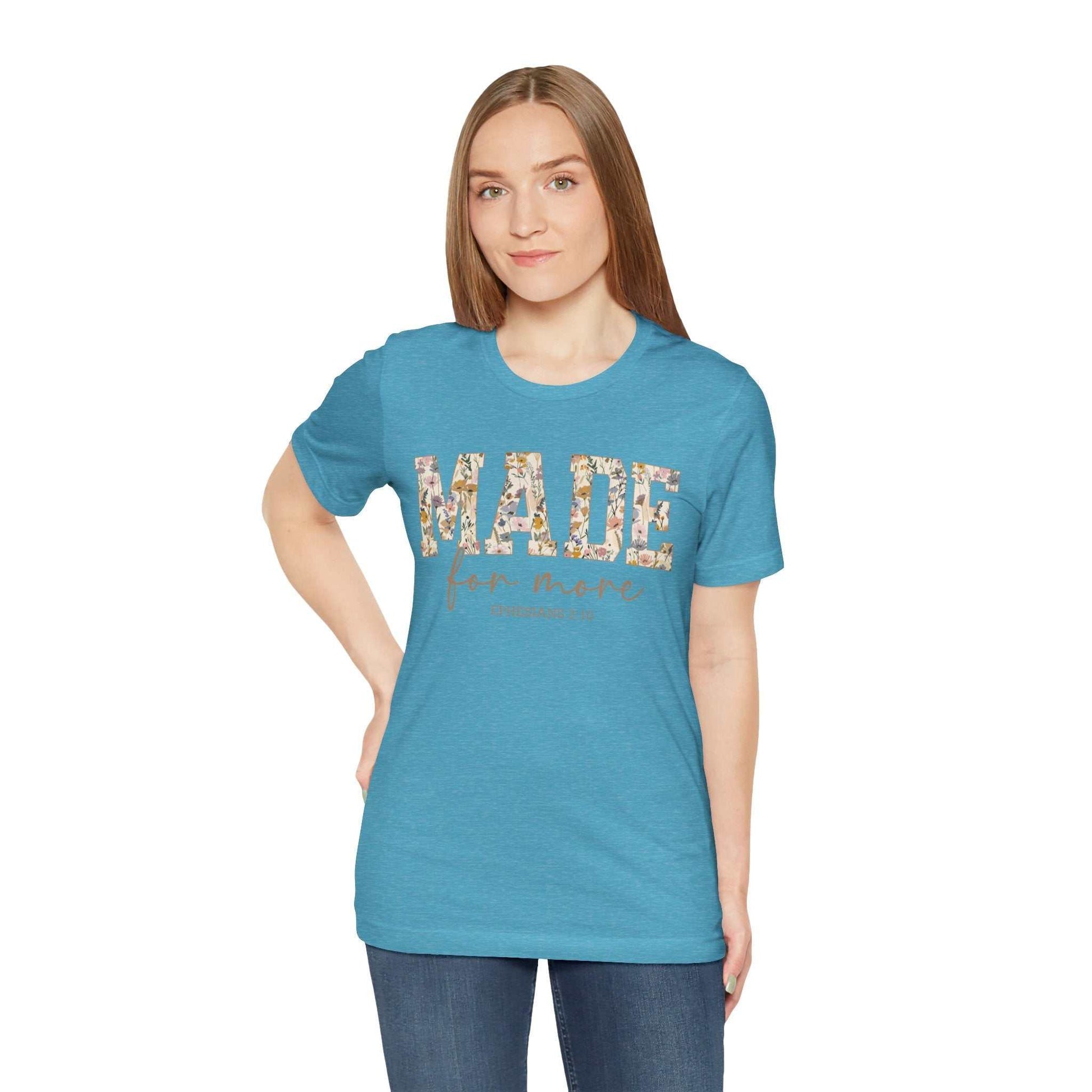 Woman wearing blue Made for More Tee with floral text design, casual fit and short sleeves.