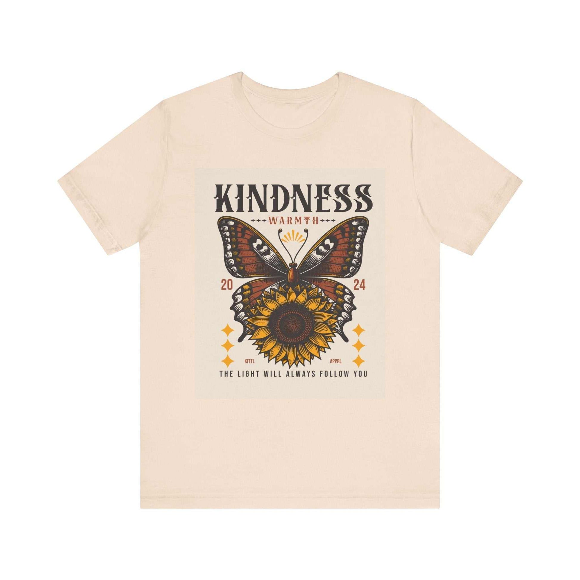 Beige Kindness Butterfly Tee featuring a butterfly and sunflower graphic with the text "Kindness Warmth 2024" and "The light will always follow you" on a unisex short sleeve cotton shirt.
