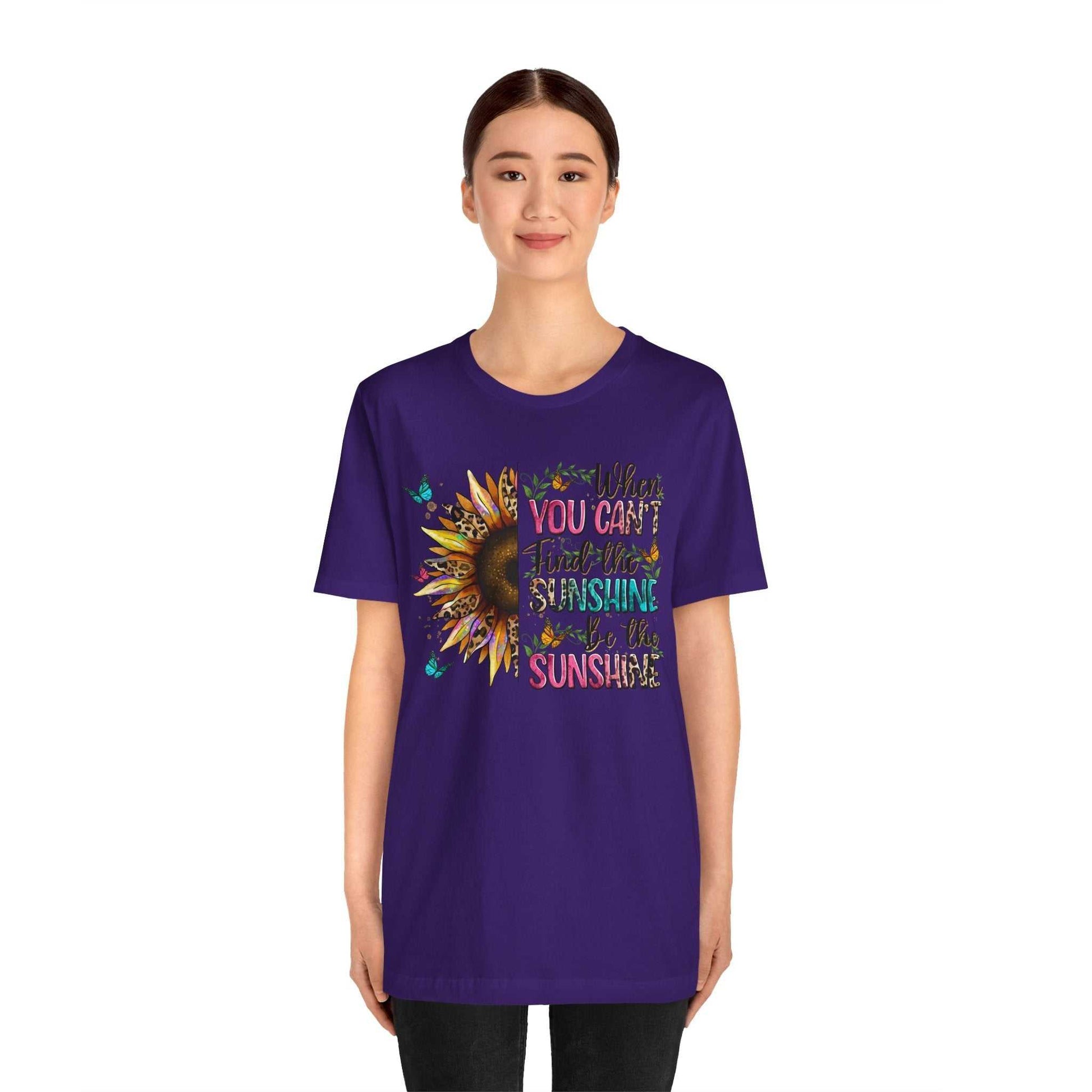 Woman wearing purple Sunshine Quote Tee with colorful sunflower and inspirational text design