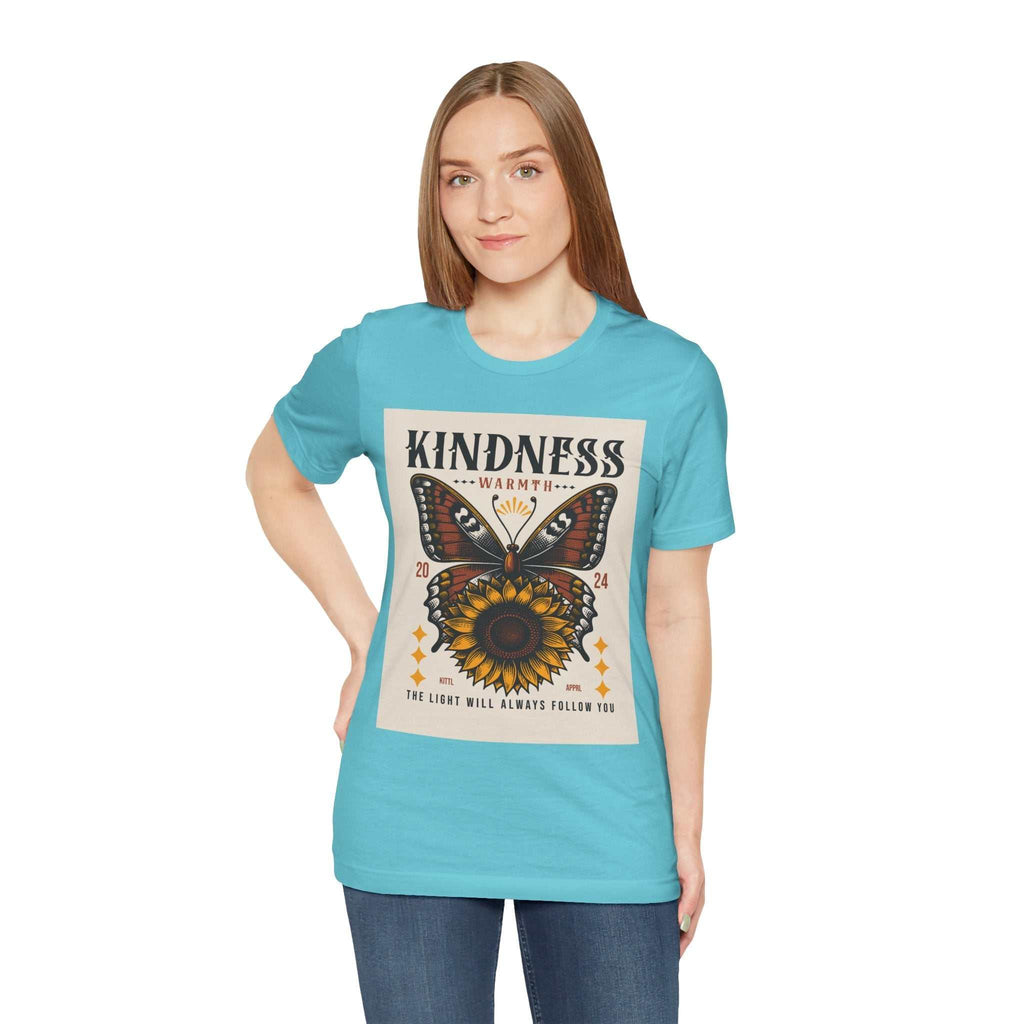 Woman wearing a blue Kindness Butterfly Tee with butterfly and sunflower graphic and positive message on front