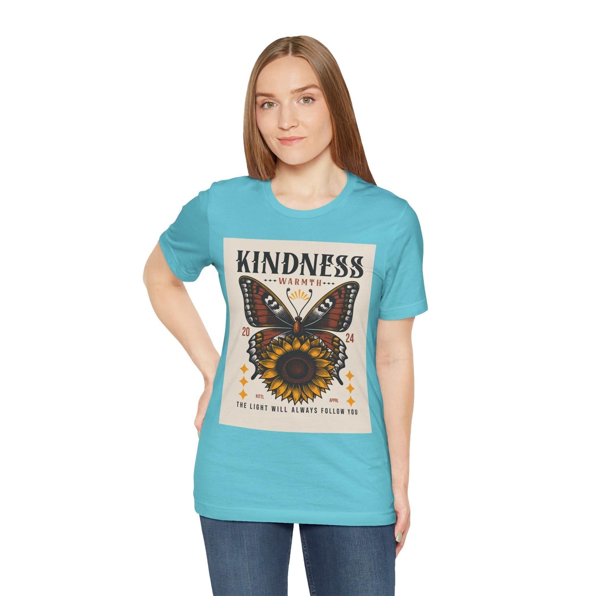 Woman wearing a blue Kindness Butterfly Tee with butterfly and sunflower graphic and positive message on front