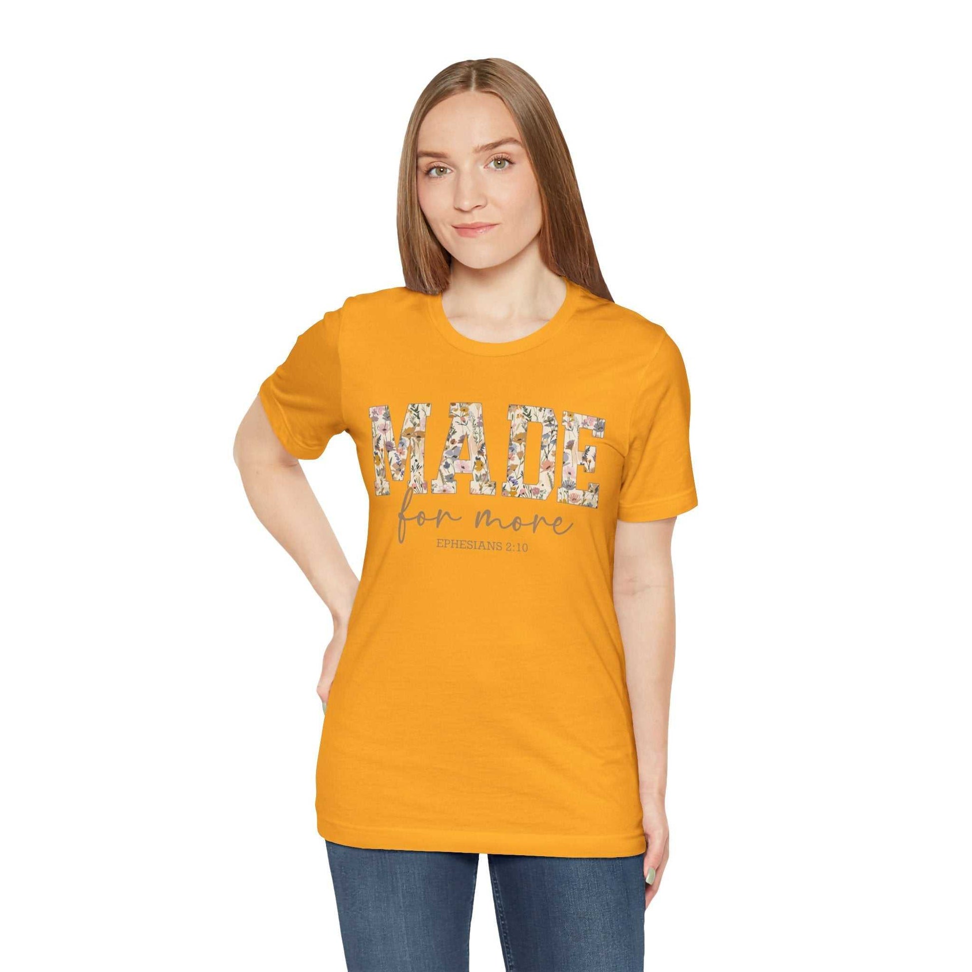Woman wearing orange Made for More Tee with floral text design on front