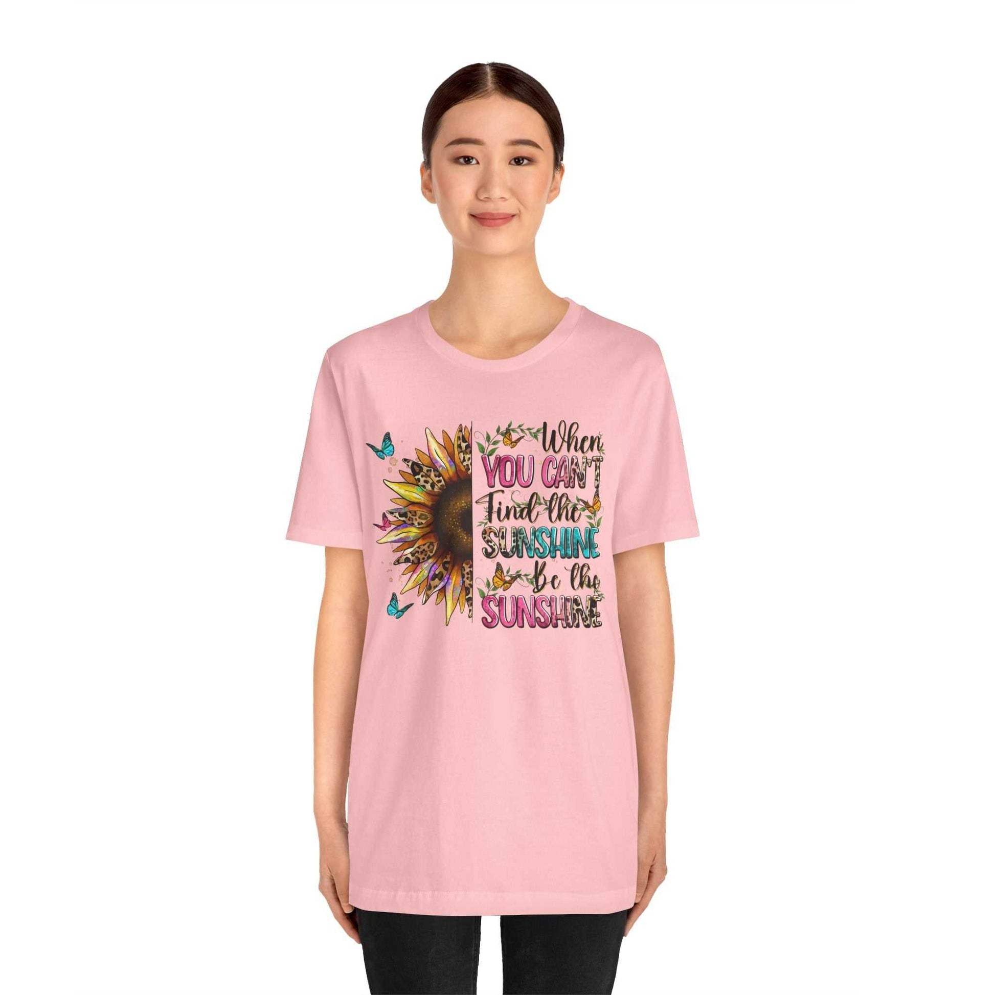 Woman wearing pink Sunshine Quote Tee with sunflower and motivational text design