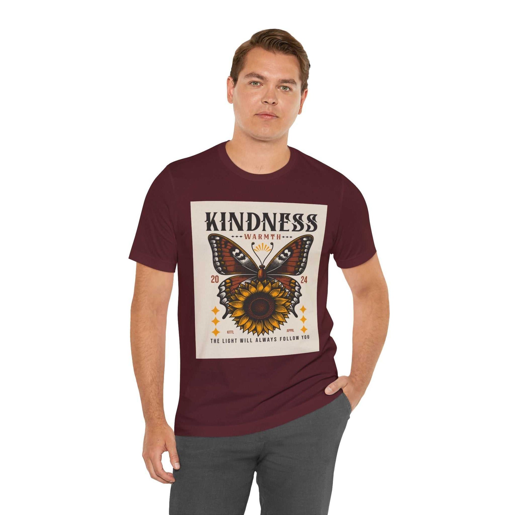 Man wearing maroon Kindness Butterfly Tee with butterfly and sunflower design and text "Kindness Warmth 2024 The Light Will Always Follow You"