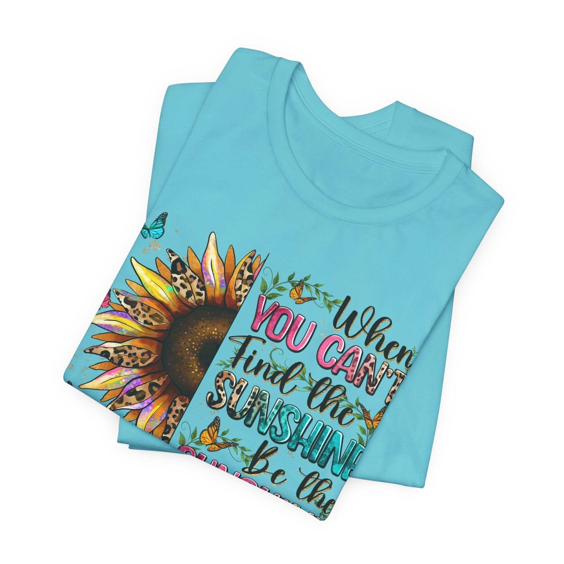 Light blue Sunshine Quote Tee with colorful sunflower and motivational text design folded flat