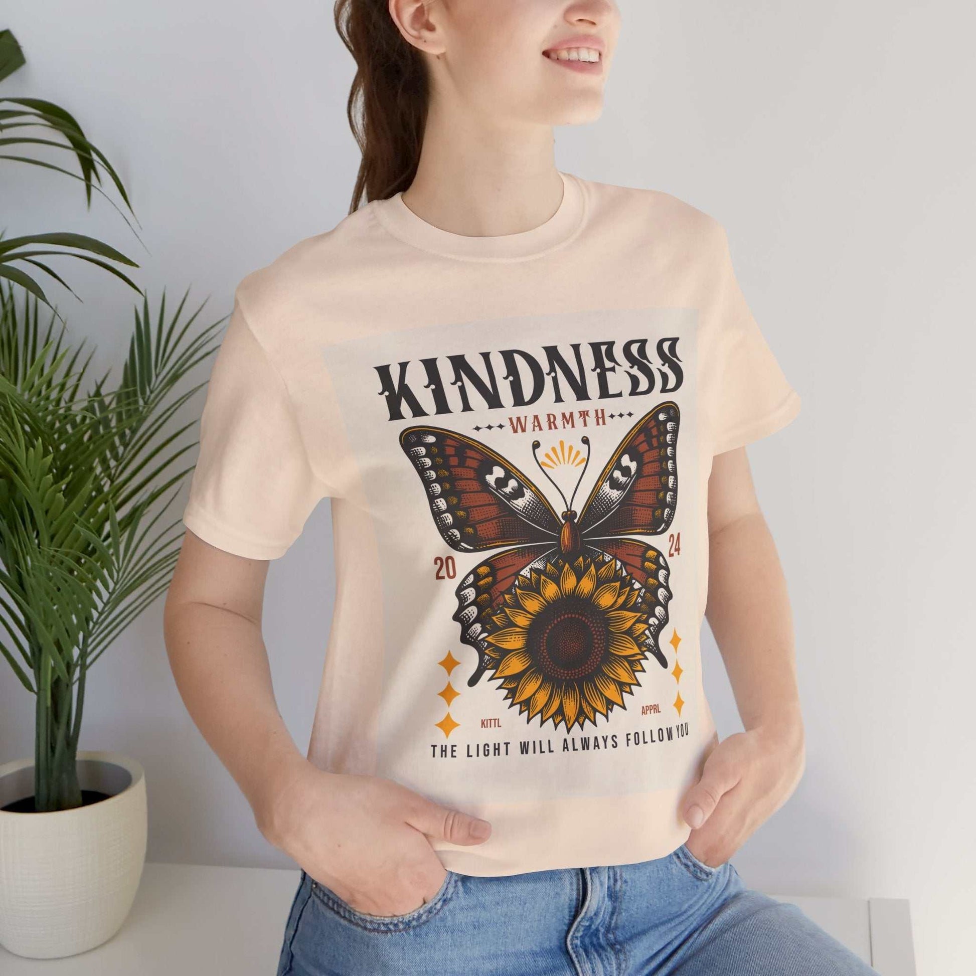 Woman wearing Kindness Butterfly Tee with butterfly and sunflower graphic and positive message