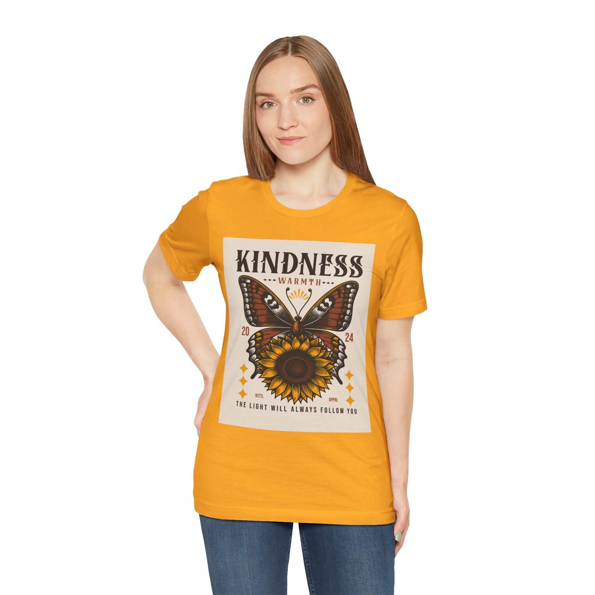 Woman wearing a bright yellow Kindness Butterfly Tee with a butterfly and sunflower graphic and positive message on front