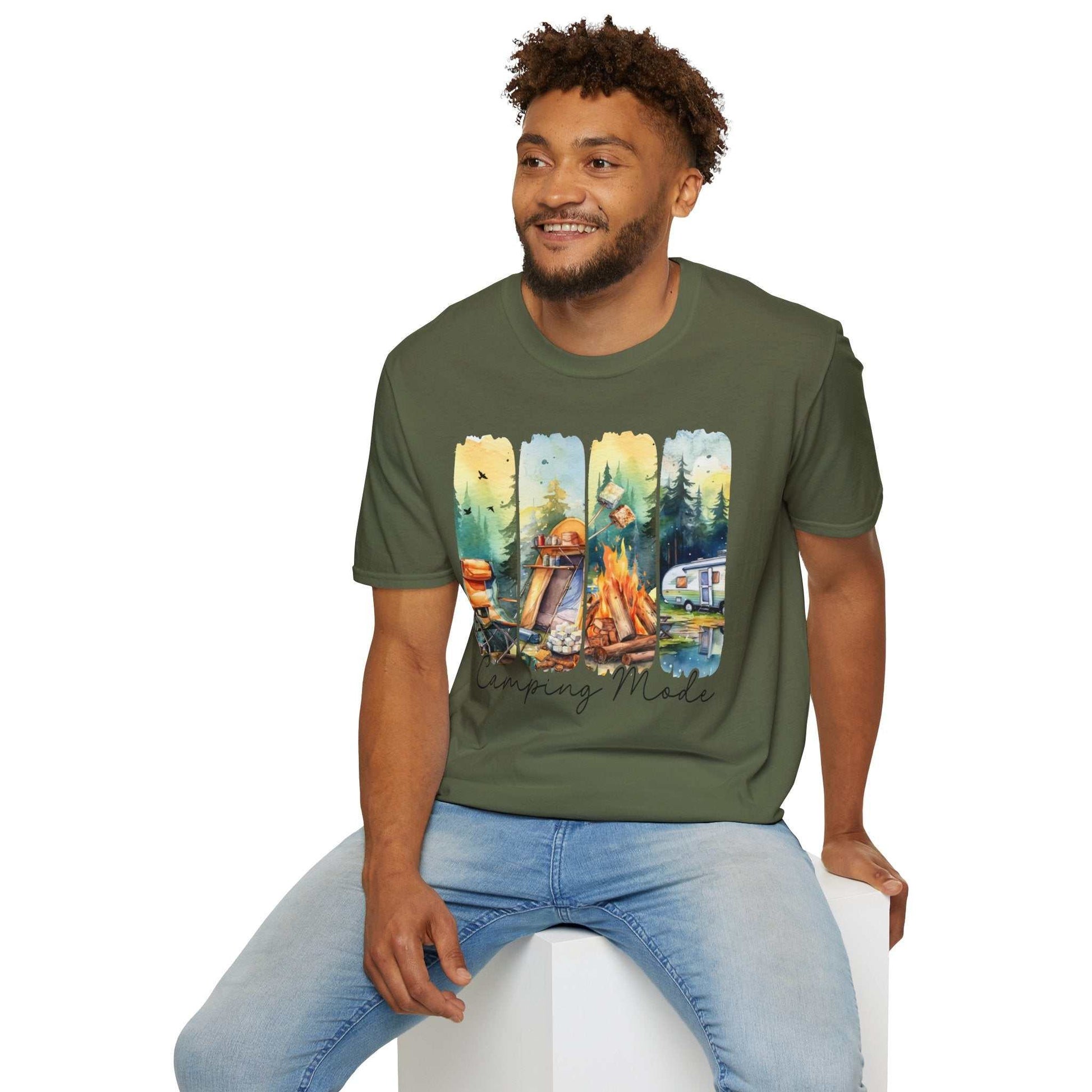 Man wearing green Camping Adventure Unisex T-Shirt with outdoor camping graphic and light blue jeans sitting on white block